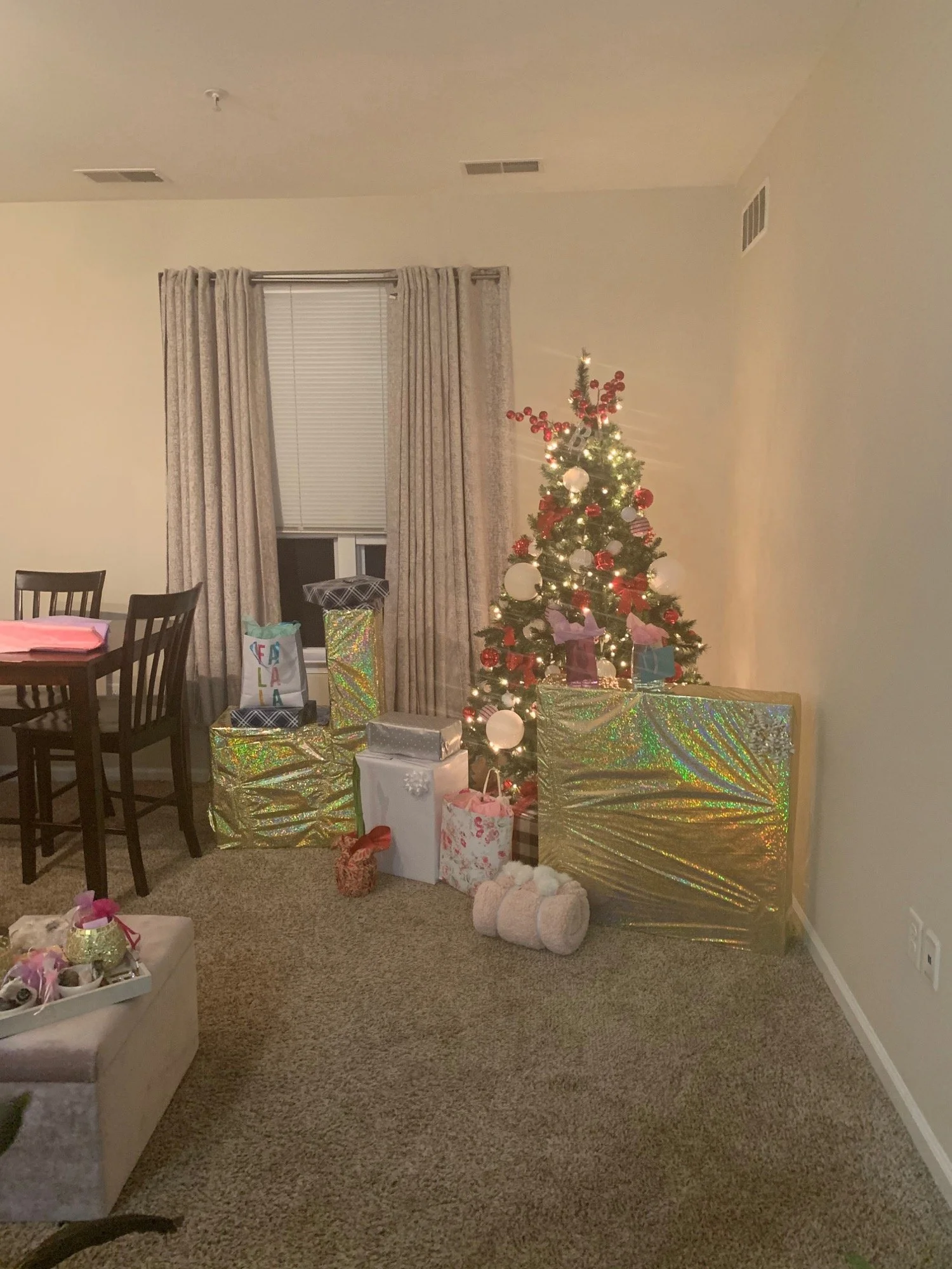 Wrapped presents around a Christmas tree in the living room