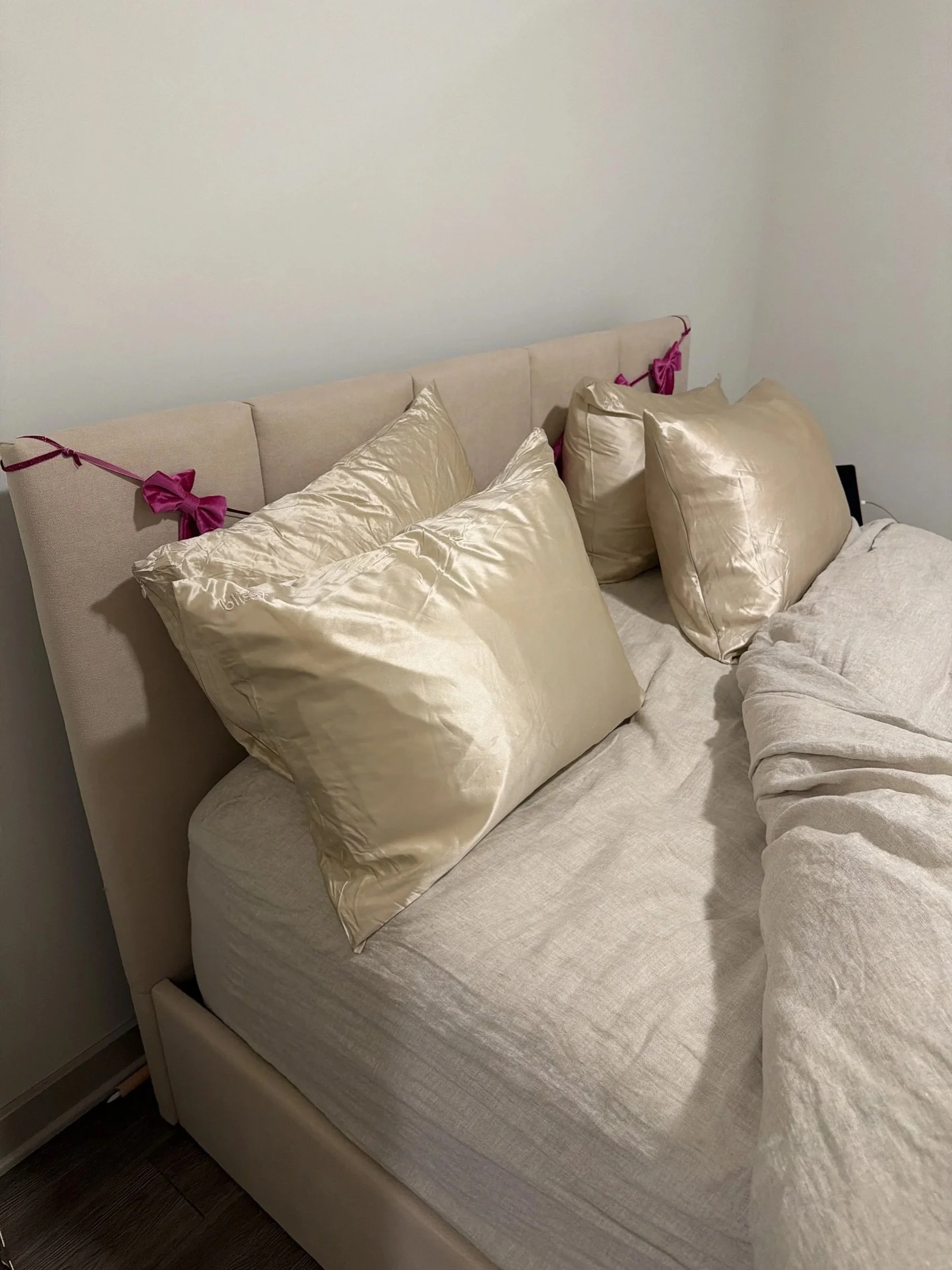 Cozy bed with satin pillows and a soft throw