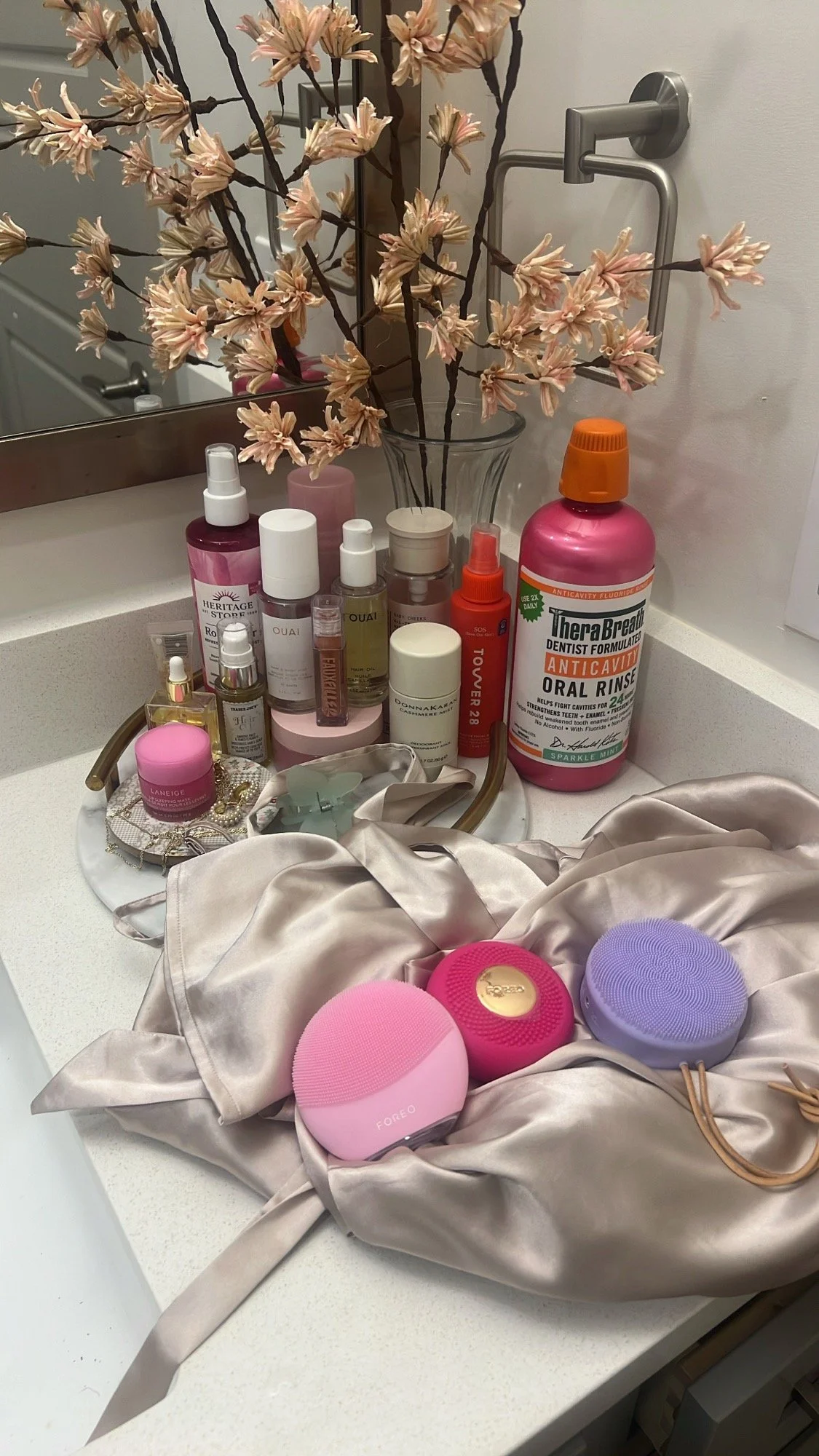 Pink skincare tools and favorites on a satin wrap
