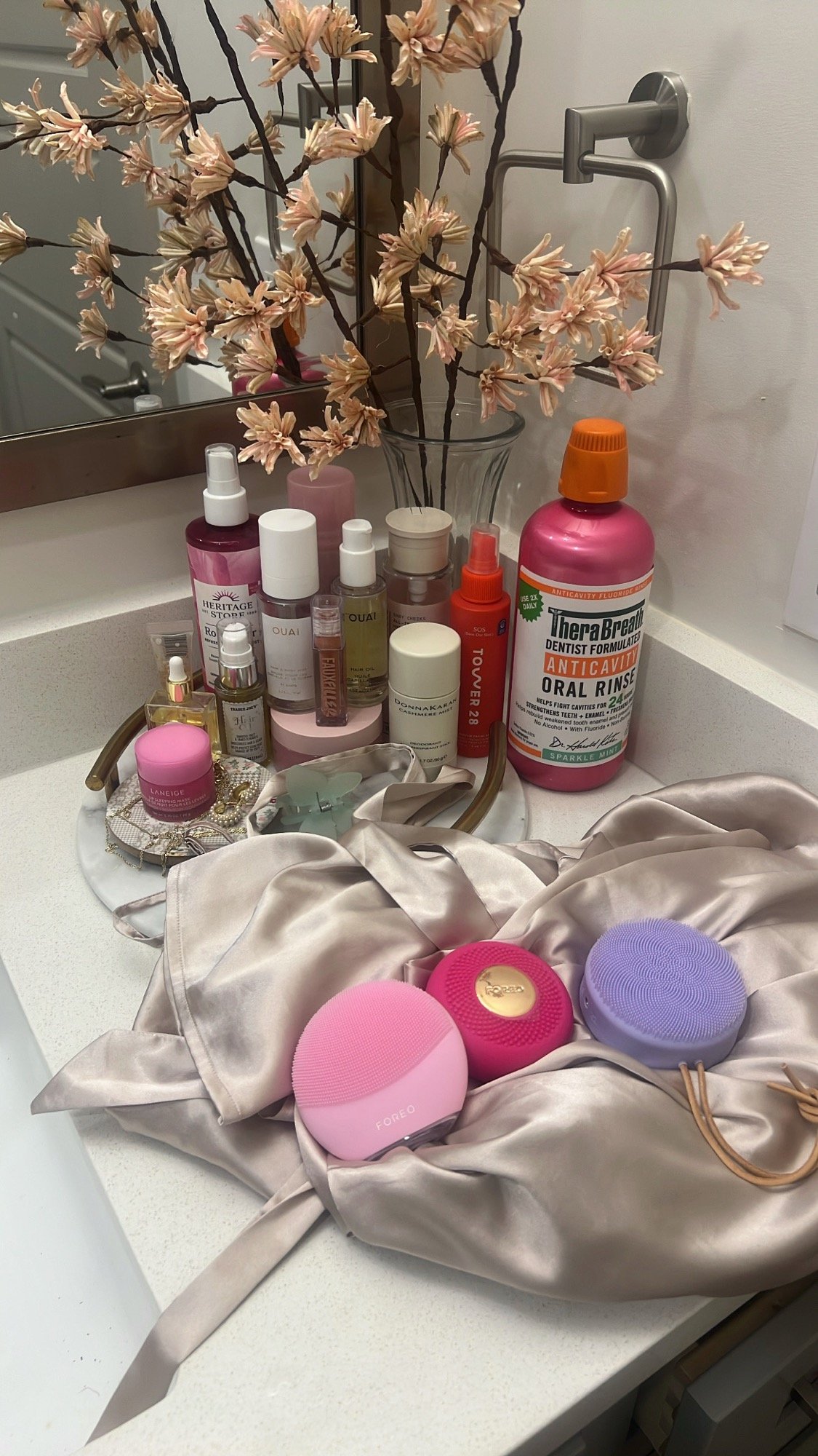 Pink skincare tools and favorites on a satin wrap