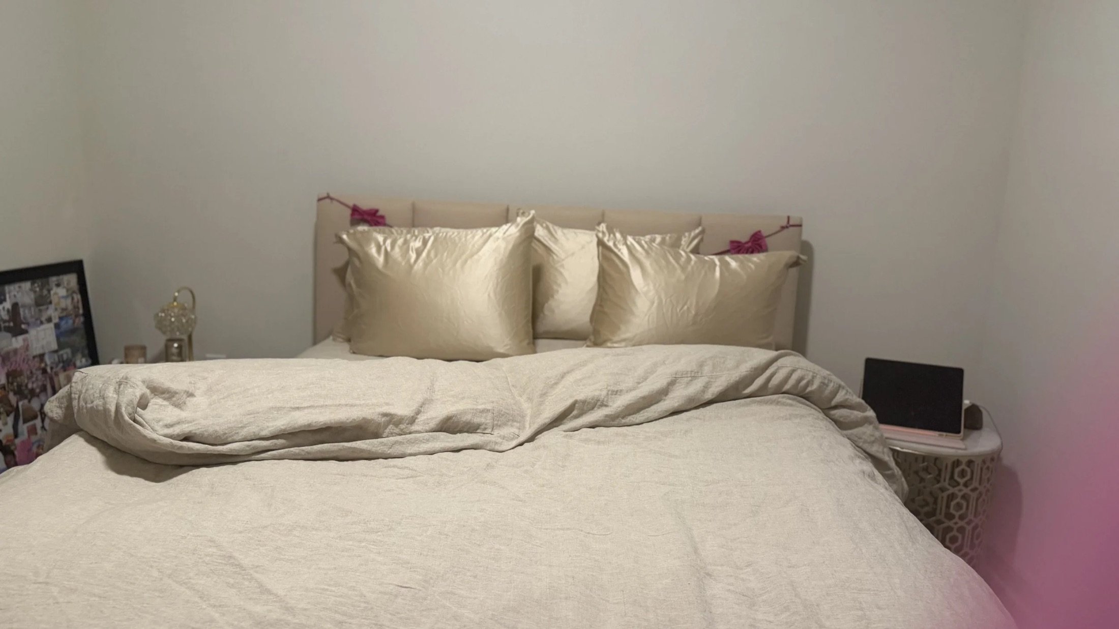 Freshly made bed with champagne satin pillows