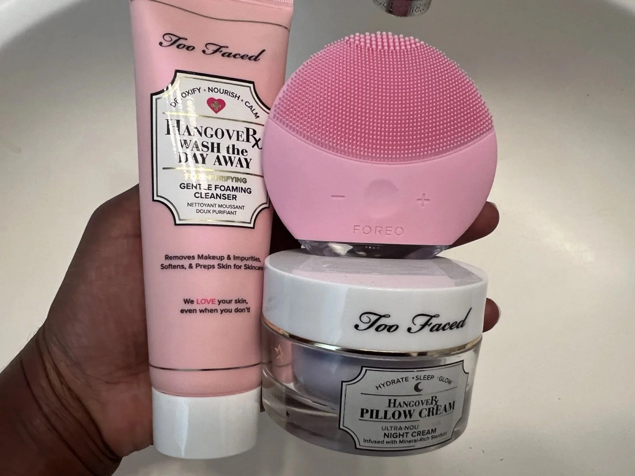 Pink face cleansing brush with Too Faced skincare