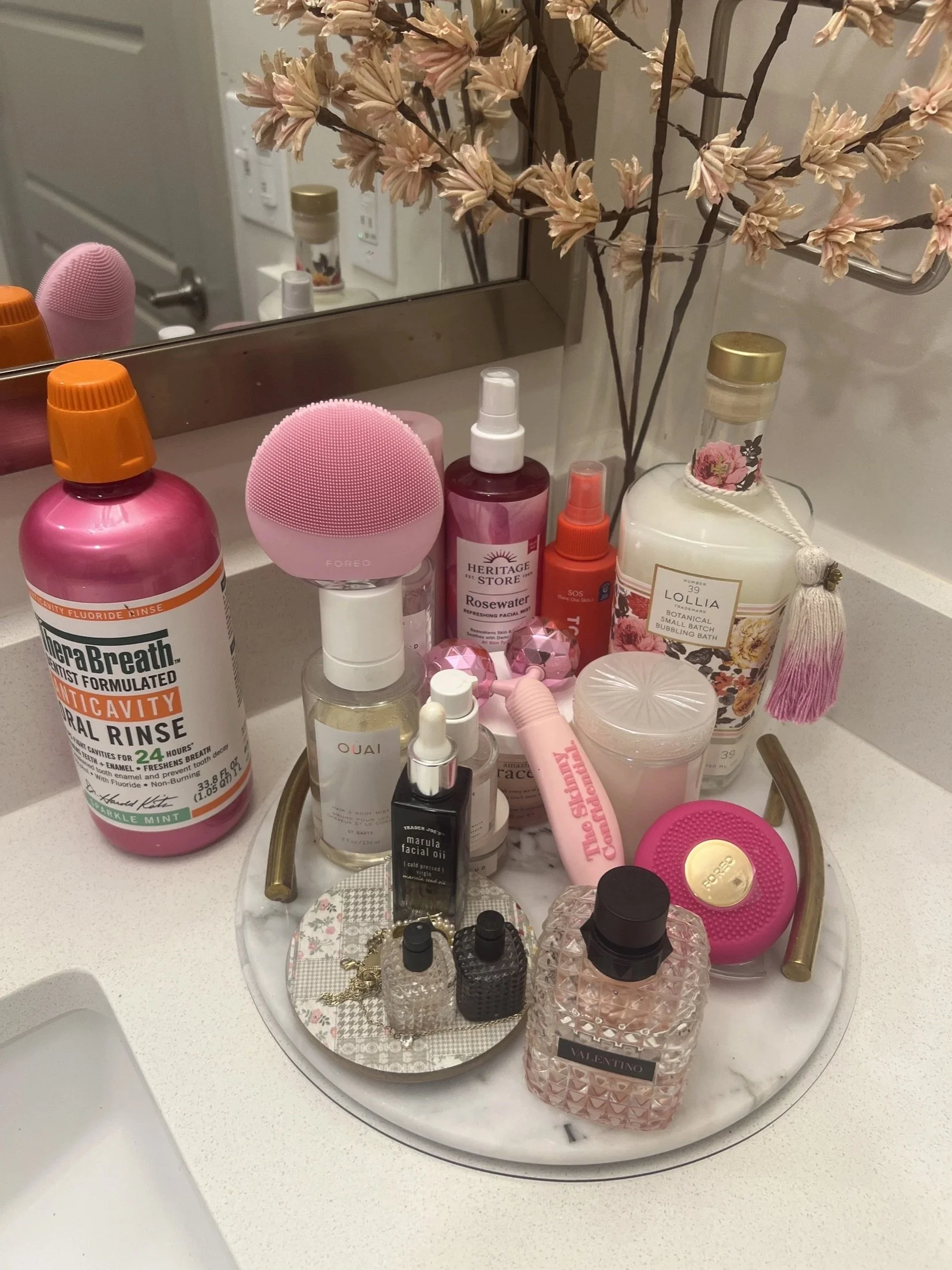 Skincare and perfume tray on a bathroom counter