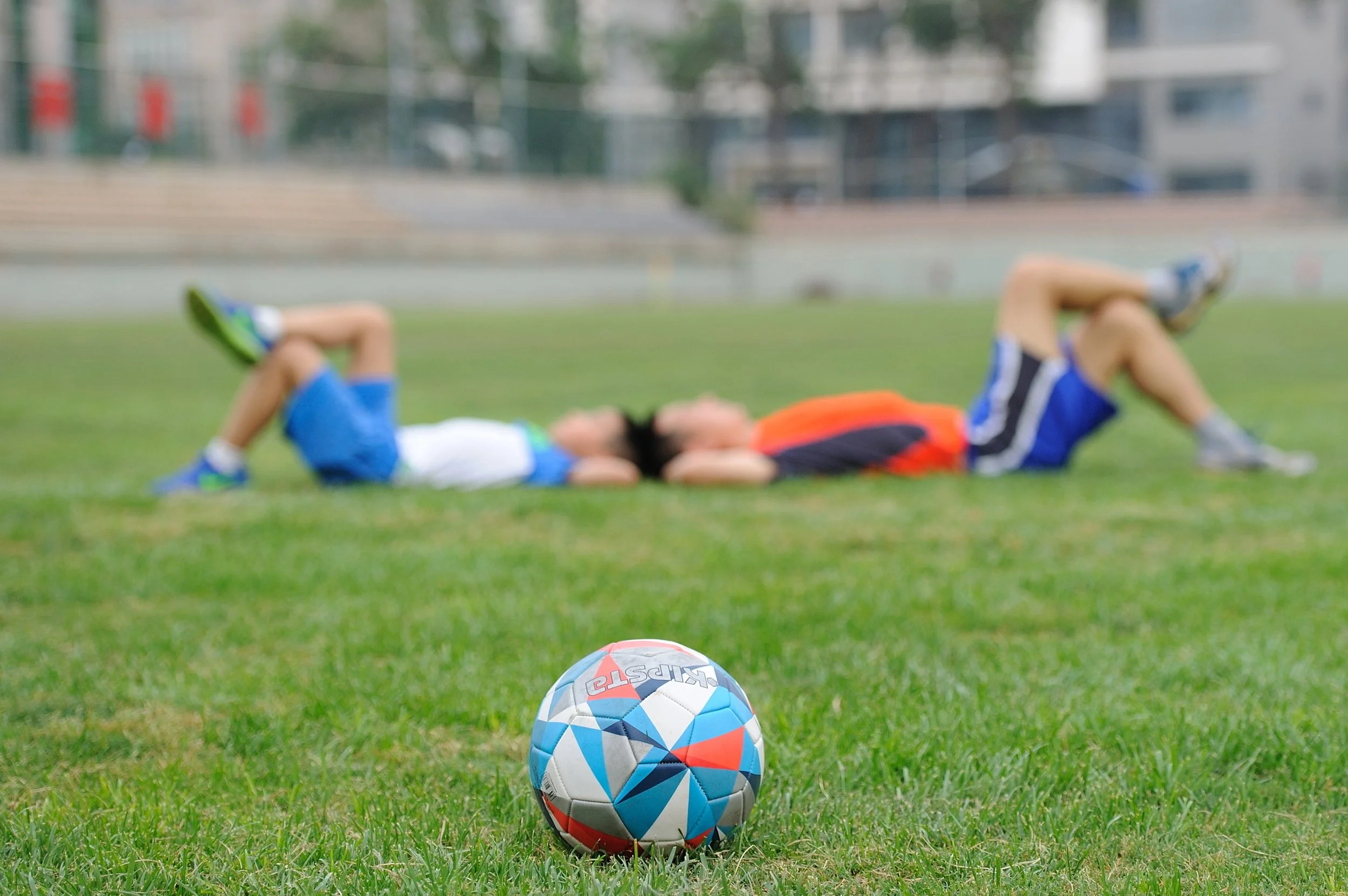 soccer players lounging with ball in foreground.jpeg