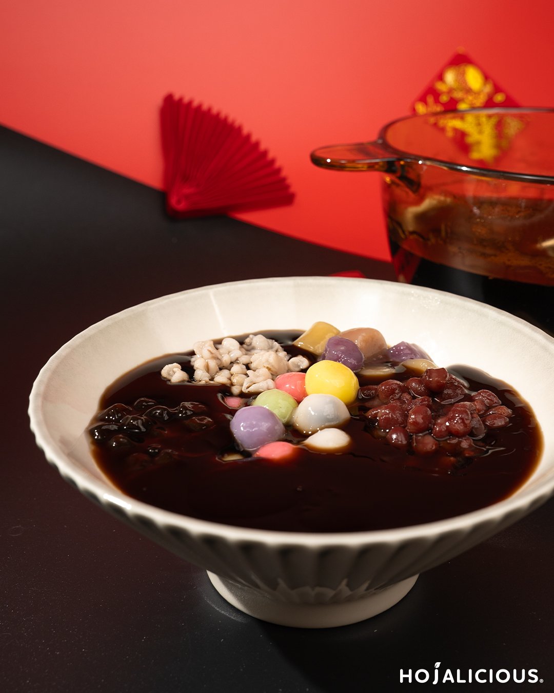 Hot grass jelly served warm with brown sugar syrup and assorted toppings, a classic herbal dessert