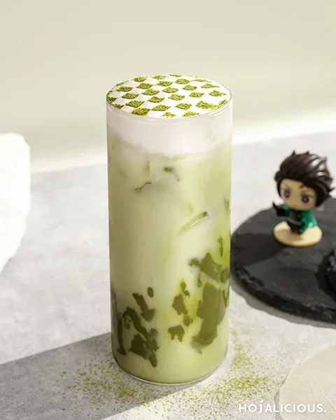 A layered matcha drink recipe with coconut milk, topped with grid matcha powder for a clean, modern café aesthetic.