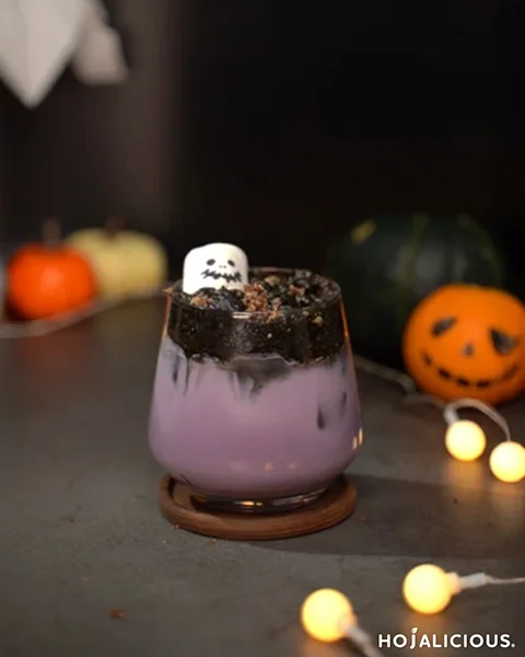 A spooky purple taro milk tea topped with black charcoal foam and ghost marshmallow — a stylish Halloween drink.