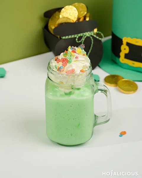 Creamy honeydew milkshake topped with whipped cream and colorful cereal crisps