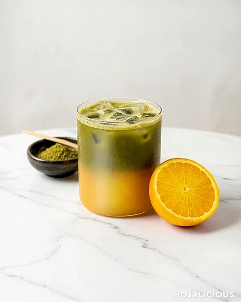 Layered matcha and orange tea with a green and orange gradient in a clear glass