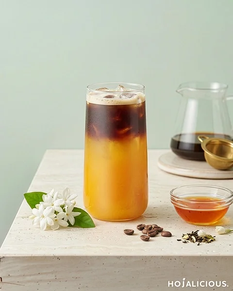 A layered Mango Jasmine Americano featuring jasmine green tea, tropical mango flavors, and a rich espresso layer creating a vibrant gradient effect.