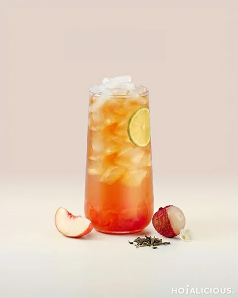 White Peach Lychee Jasmine Green Tea made with Jasmine Green Tea, White Peach Jam, Lychee Syrup, Lychee Nata de Coco, and a Dried Lemon Slice, creating a refreshing fruit tea with delicate floral aroma and layered fruit flavors.