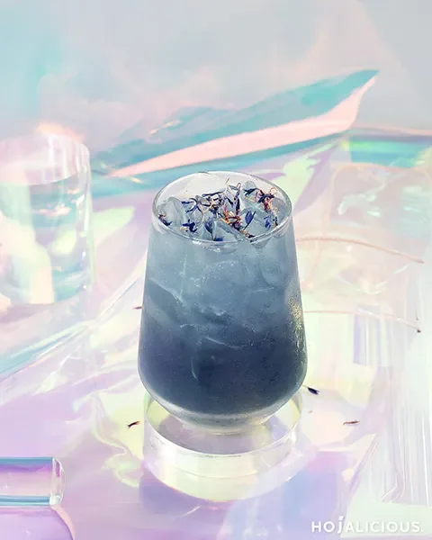 Galaxy Blue Cotton Candy Fizz made with Cotton Candy, White Shimmer Powder, Taro Syrup, Lychee Syrup, Lemon Juice, and Sparkling Water, creating a shimmering galaxy-inspired sparkling beverage.