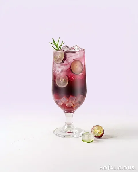 Sparkling grape oolong tea with aloe vera, grape pulp, ice, and a rosemary garnish in a tall glass.