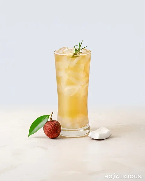 Lychee iced tea made with Jin Xuan oolong tea, coconut water, lychee syrup, and lychee coconut jelly, garnished with rosemary.