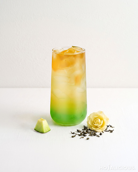 Honeydew camellia oolong tea in a clear glass: green honeydew base, golden oolong tea, ice, and camellia oolong tea jelly on top.