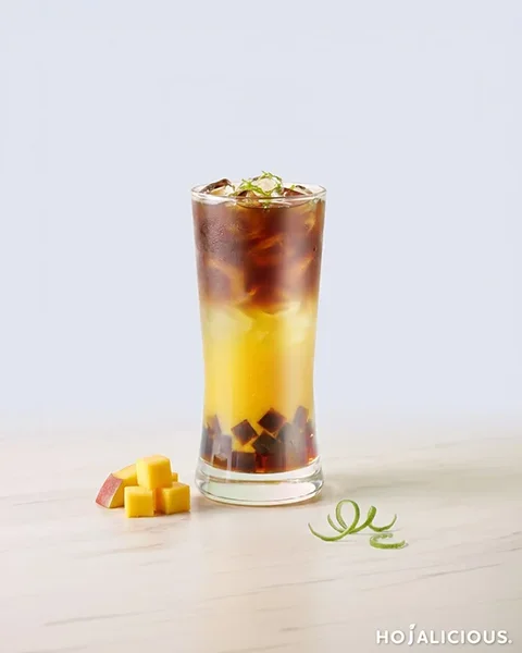 Mango Oolong Cold Brew Coffee made with mango jam, oolong tea base, cold brew coffee, Coffee Agar Boba, ice, and lemon zest, featuring a golden mango tea base with a dark cold brew coffee layer.