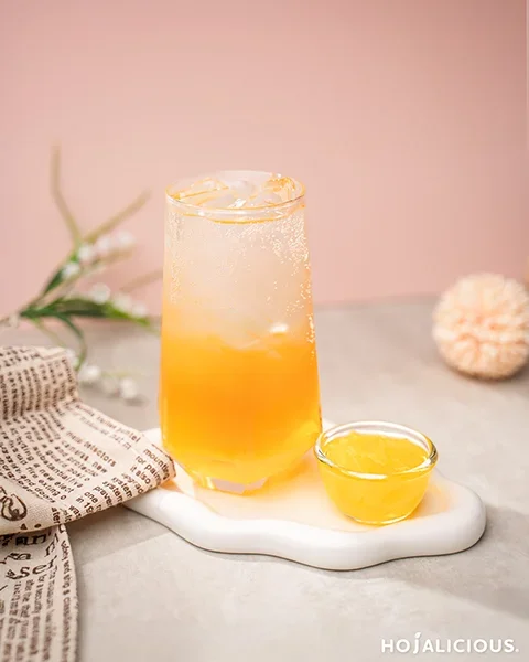 A refreshing Peach Sparkling Jelly Tea with juicy peach flavors, fizzy soda, and chewy coconut jelly, creating a fruity and bubbly iced tea experience.