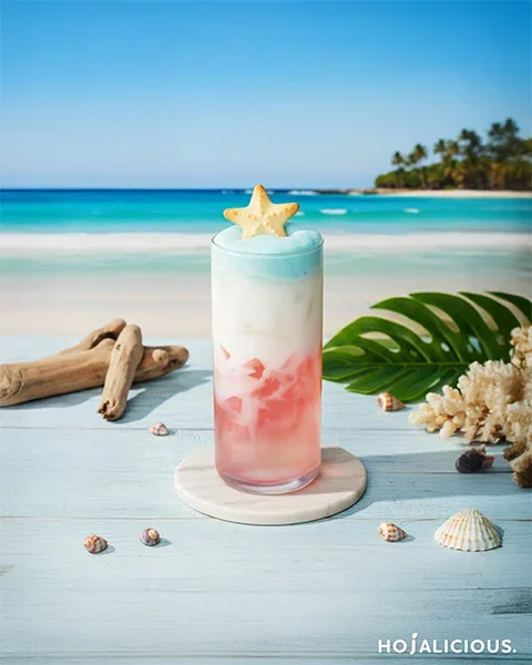 Coconut drink with sakura agar jelly and blue curaçao cream foam in a layered summer beverage