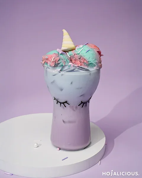 Colorful layered taro milk tea float topped with ice cream, sprinkles, and marshmallow decoration