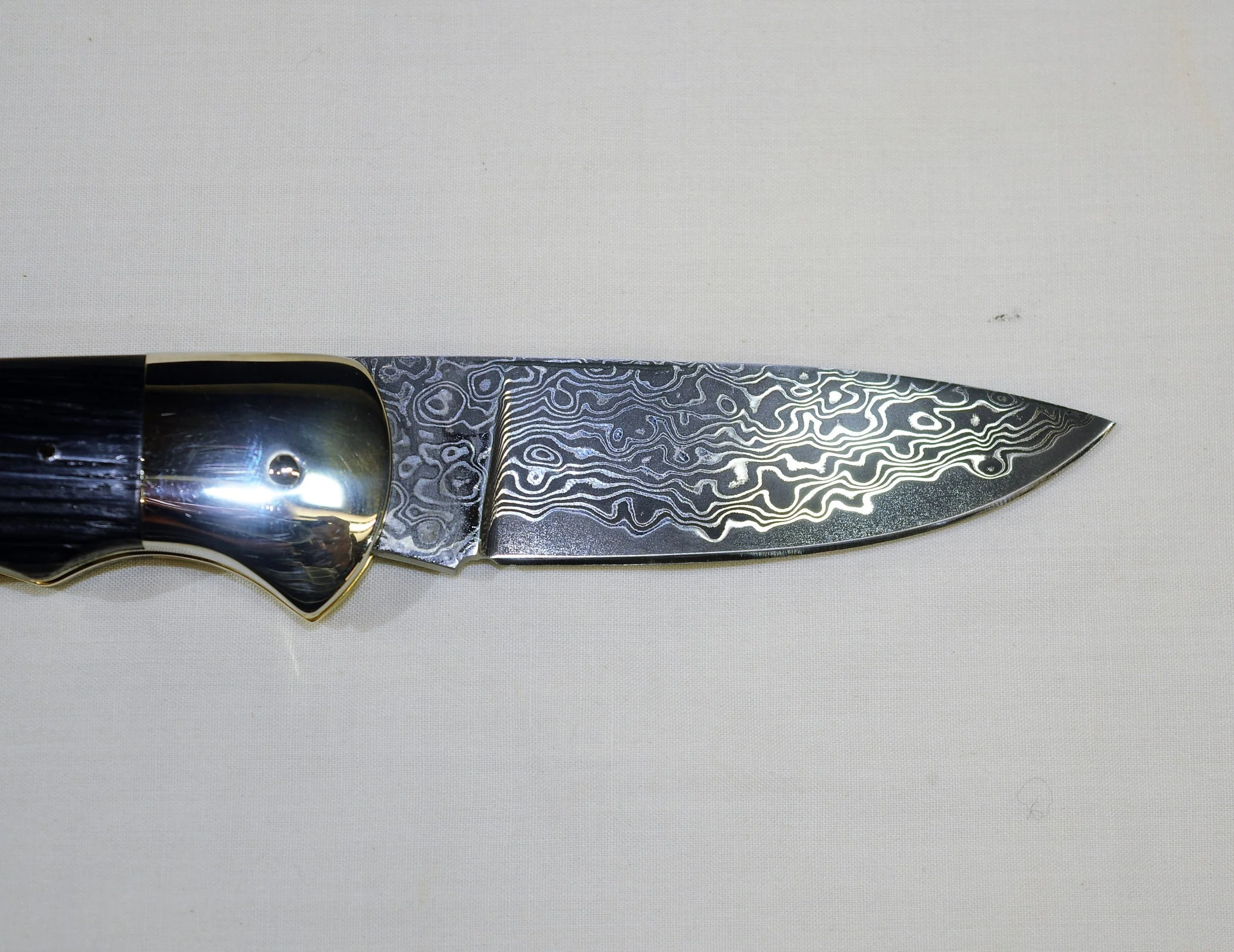 Damascus FolderThe Damascus Folder knife has a Neolithic Oak handle to compliment the 3.25″ etched blade which is heat treated and cryo-quenched to attain 62 Rockwell C. It is fitted with Stainless steel bolsters and supplied in a leather flip top c…