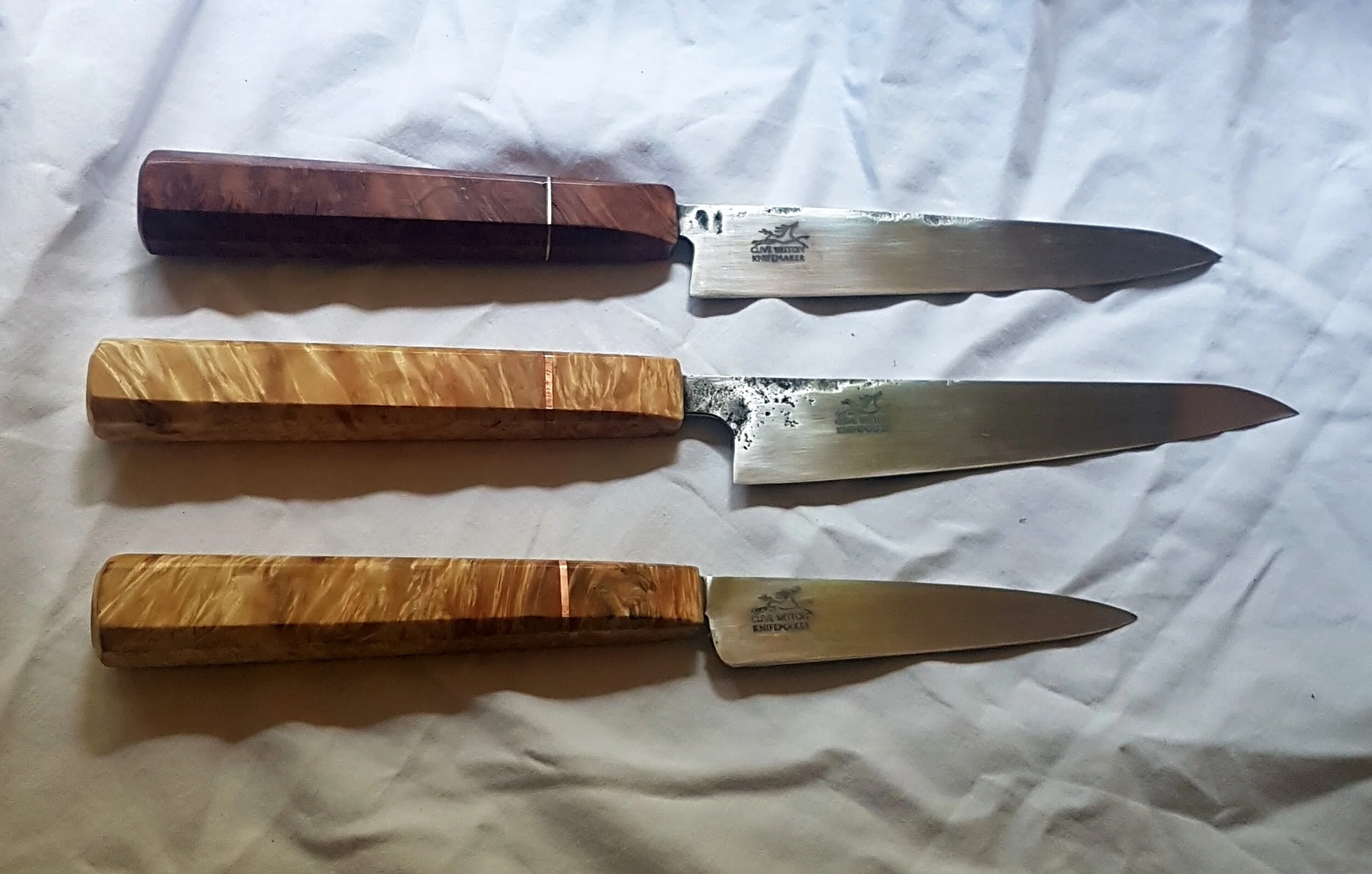 Pairing KnivesThree Paring Knives blades all in 125sc Carbon Steel the top knife with a Coolabah Burl and Silver handle the lower two knives in Maple Burl with Copper spacers