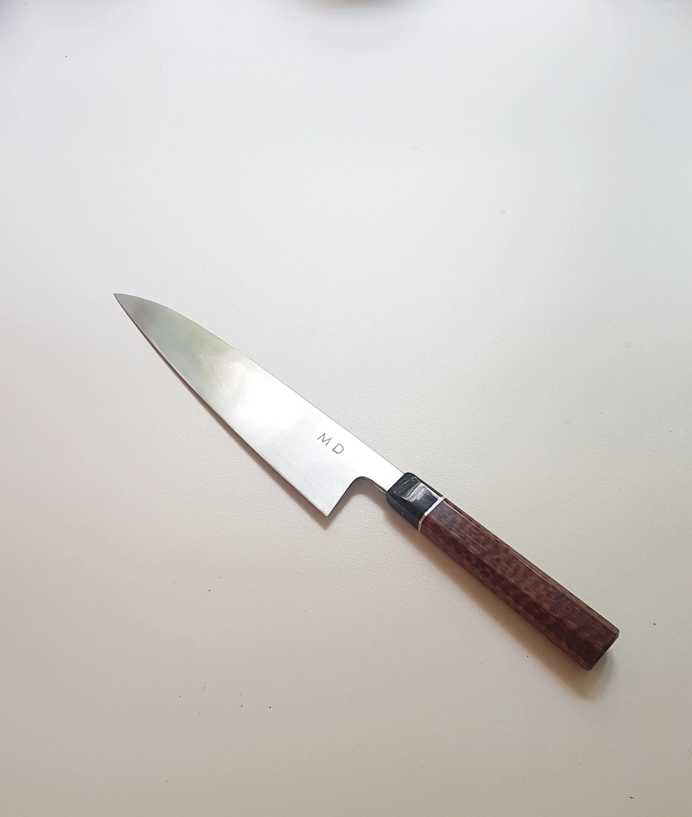200mm GyutoThis Gyuto is specifically intended for general food preparation. The blade is hand-made from DIN 115W8 (1.2442) a specialised knife steel made by Lohmann-Stahl in Witten, Germany.1.2442 is by general definition a High Carbon Steel with a…