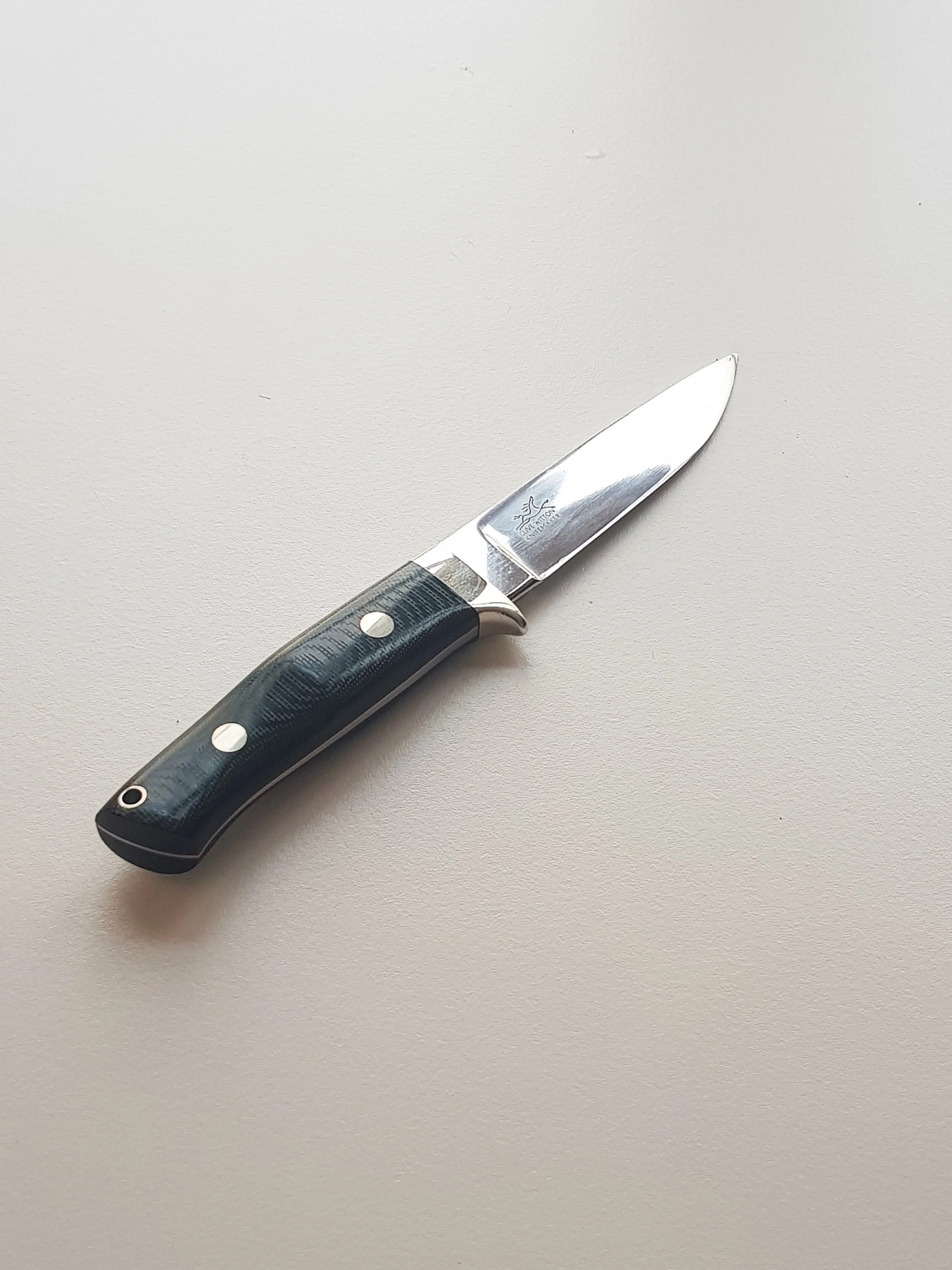 Drop Point HunterThis knife is a Drop-Point Hunter in the style of Bob Loveless. The hollow ground blade is &nbsp;4 3/8″ long and the cutting edge is 4″ x .160″ thick with a distal taper in both directions from the guard. The blade is made from Hita…