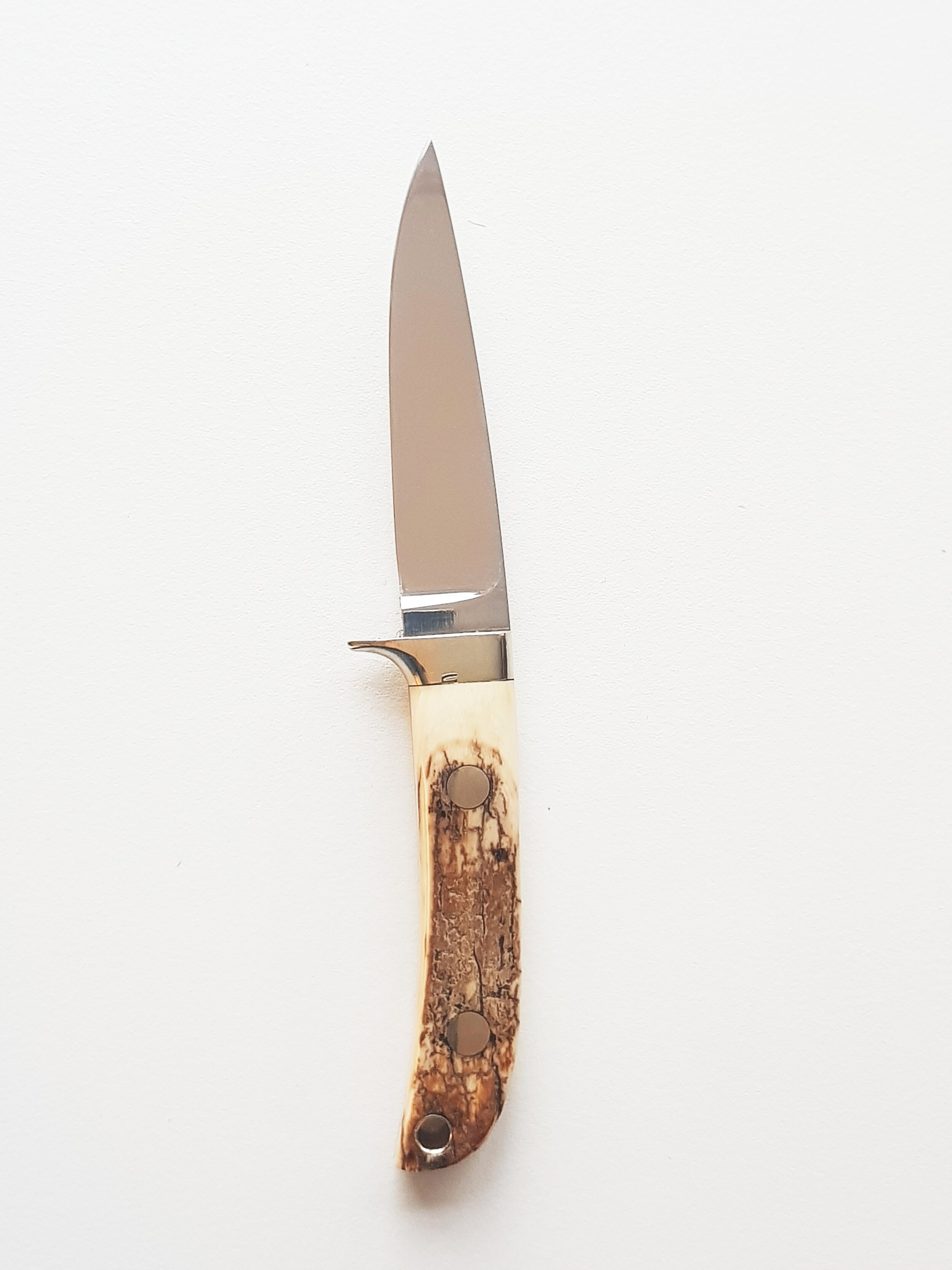 Slim HunterI have made this Slim Hunter knife and its sheath entirely from the very best materials.It has a hollow-ground, drop point blade 3 3/4″ long and 0.130″ thick with a distal taper to the point and through the tang. The handle is Mammoth Ivo…