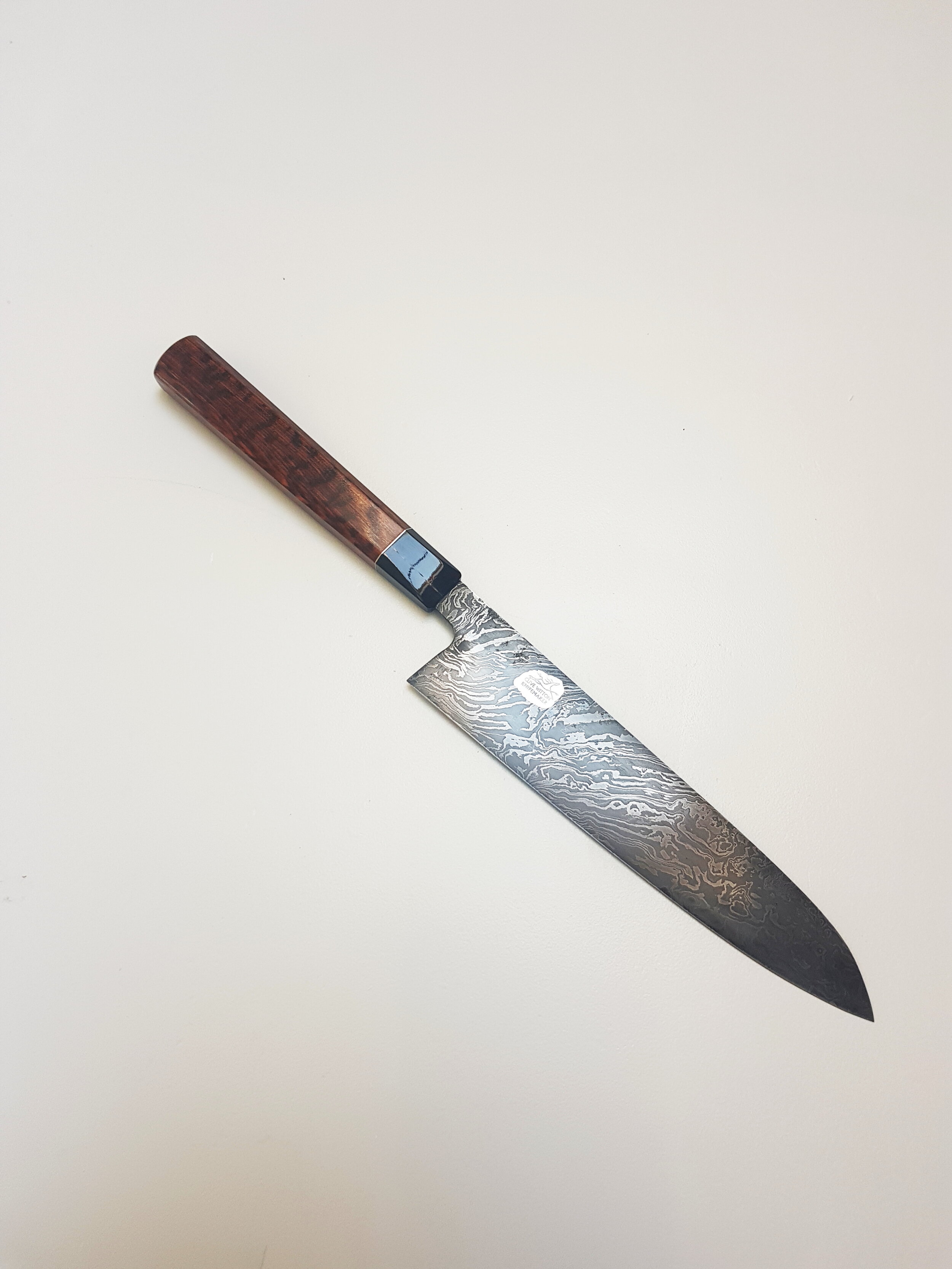 200mm GyutoThis 200mm Gyuto is hand forged from a piece of Damascus composed of types 1090 and 15N20 Carbon Steel. The steel was made by forging together the two steels then folding and then twisting them to produce a solid billet with approximately…