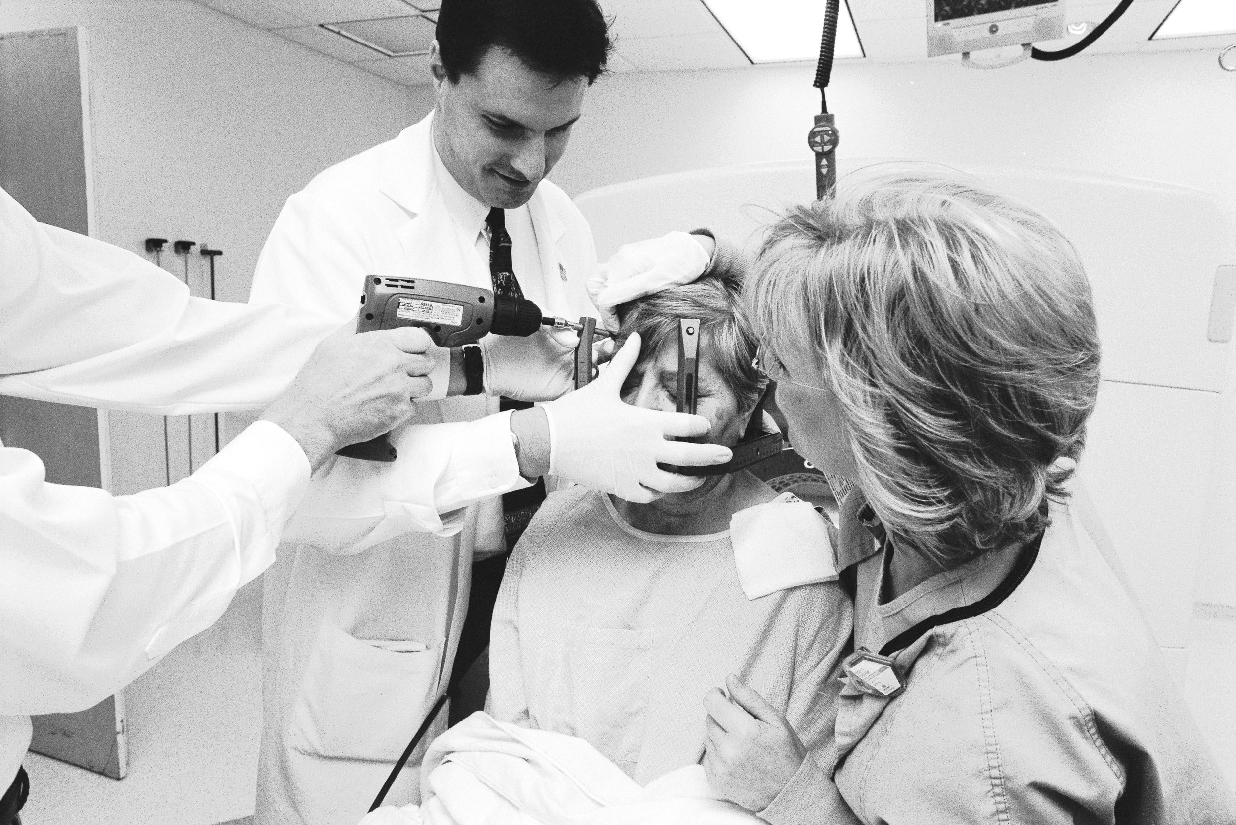  A patient having the frame removed from her head. Although it looks like the doctor is drilling the screws into the patient's head, he is actually using the drill to 'unscrew' the frame from her head. 