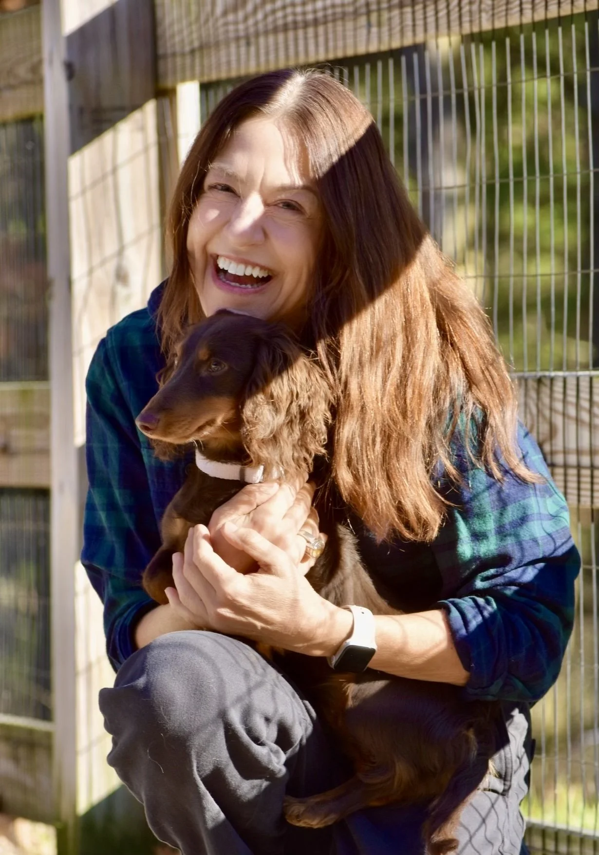 Kat Egan, Head of Growth & Marketing at Far Fetched Acres, pictured outdoors holding a small dog.