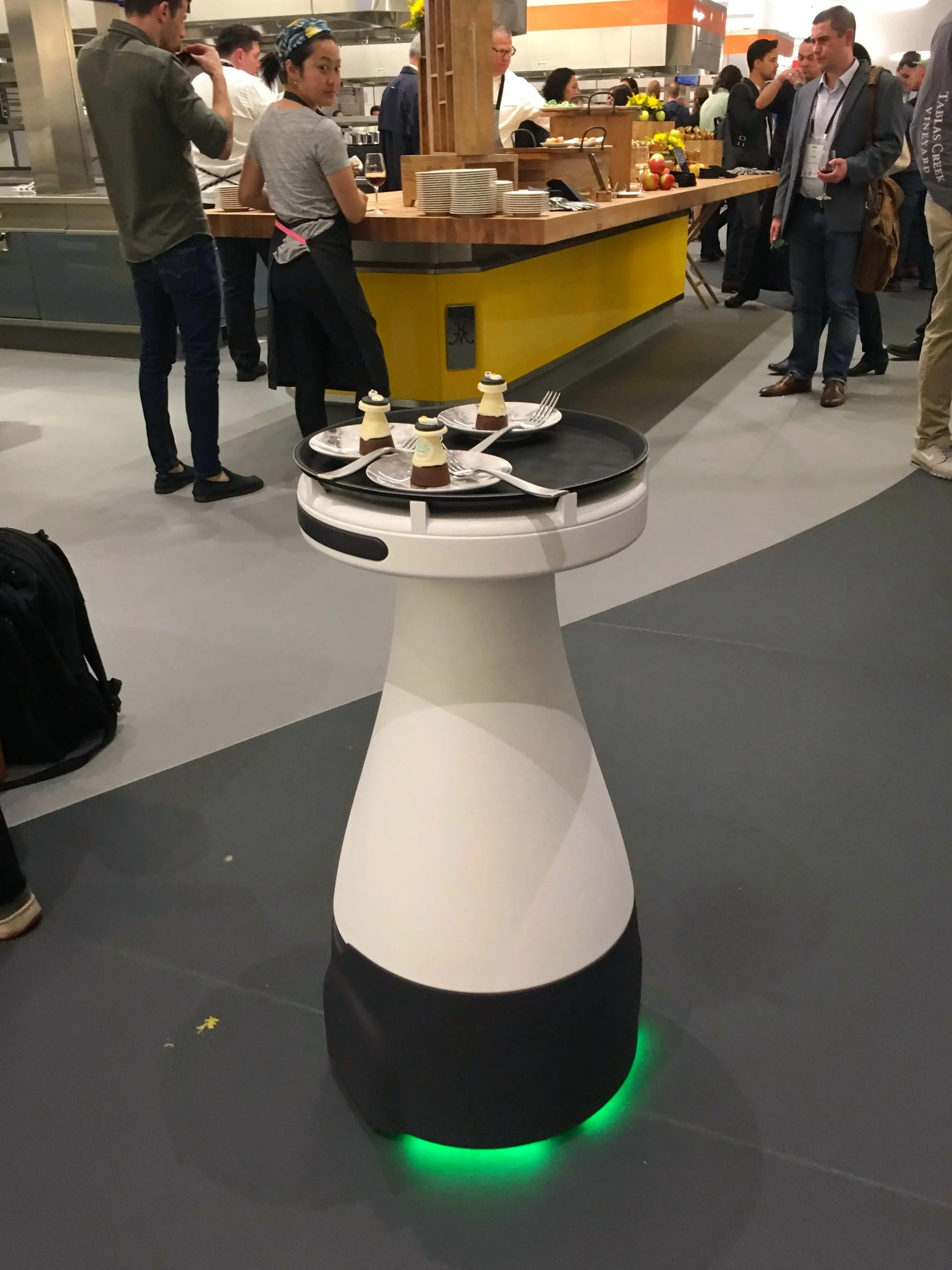 I attended a reception tonight at the Culinary Institute of America in Napa, which was part of the reThink Food conference. They had self-driving robot waiters from Bear Robotics , which hold a tray and wander around serving desserts from a black tray on top of the robots.