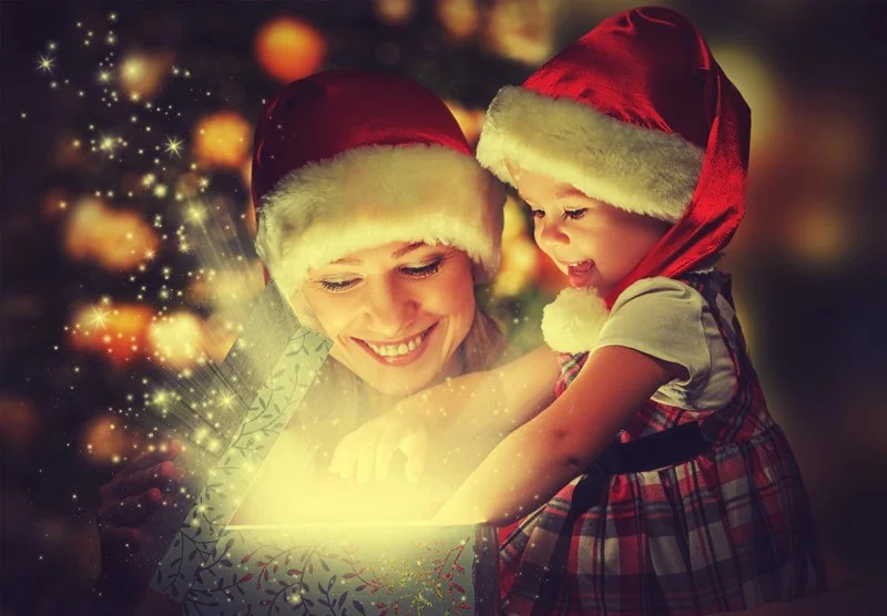 Mother and young daughter celebrating the holidays wearing Santa hats