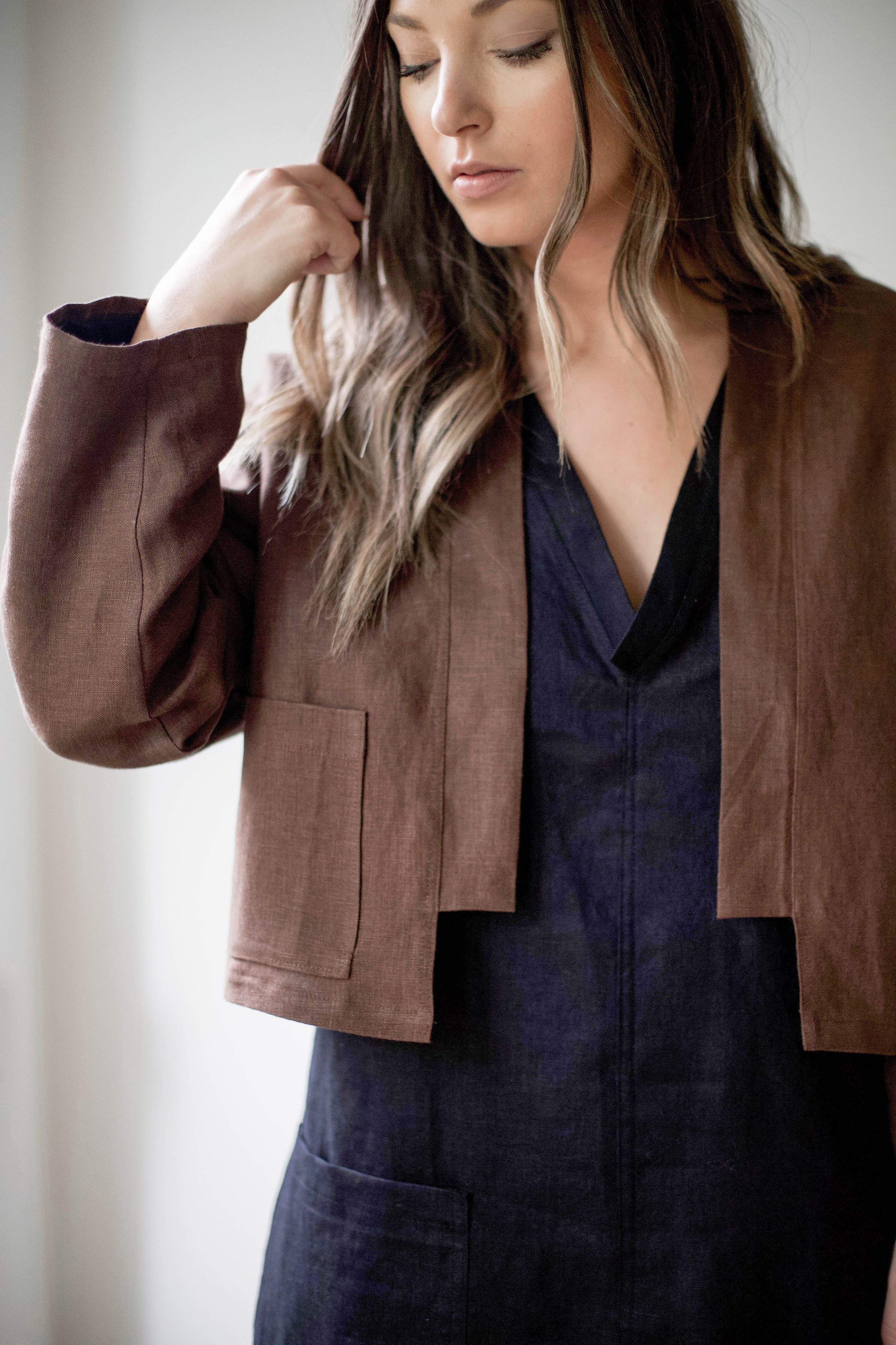 nomi-designs_ann-jacket_chocolate-colored-natural-linen-jacket_front-pocket-detail_paired-with-linen-dress.jpg