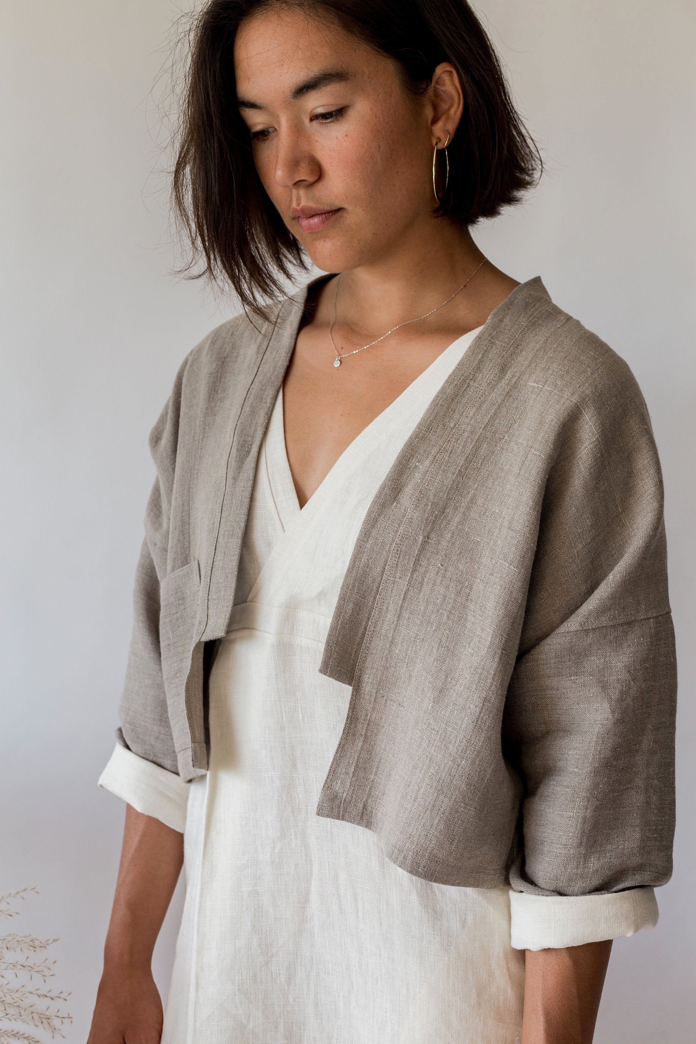 woman wearing ann linen jacket with cropped open front and single pocket in natural
