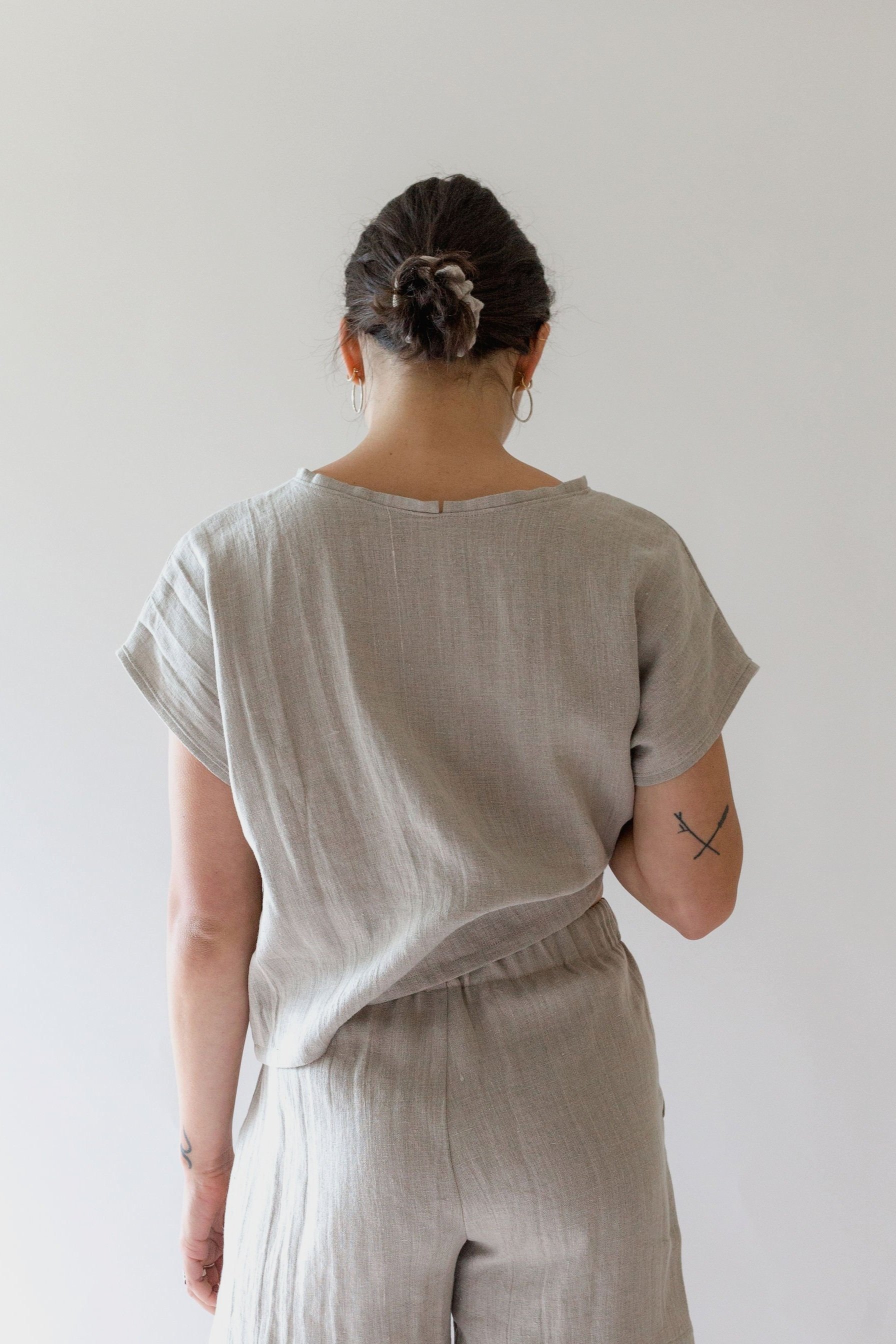 Back view of model wearing the Jessie linen top by Nomi Designs in ivory
