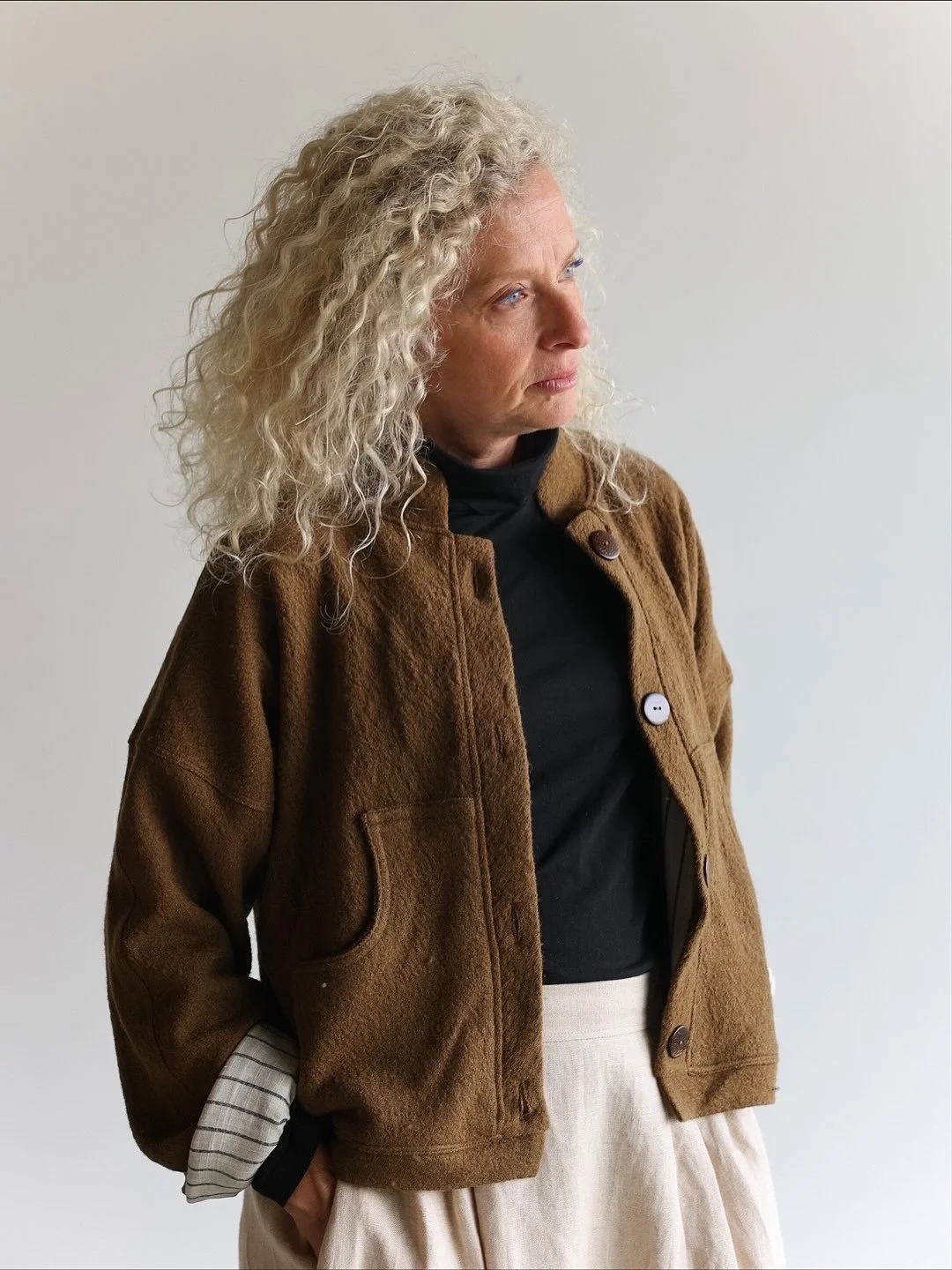 The Eden double-layer jacket in Bark, made with one layer of wool and one of linen, is perfect for cooler days. In the photos, Sigal wears it open over a black turtleneck top, paired with a Natural linen skirt and black boots. The mix of materials an