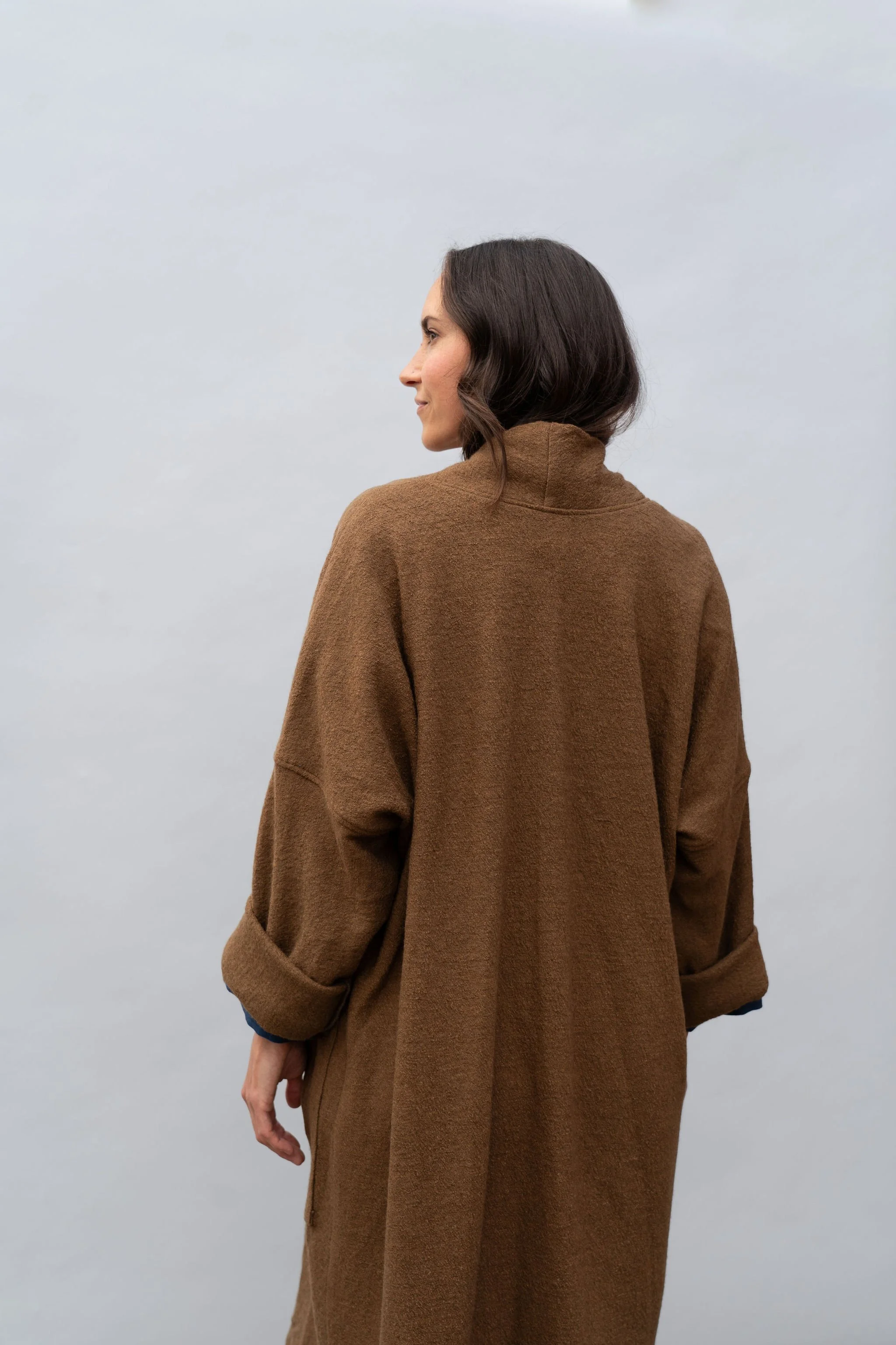 Back view of a woman wearing a wool coat in Bark looking left