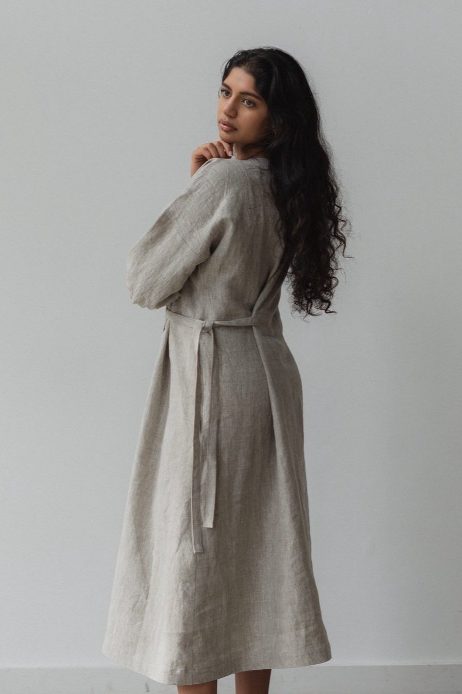 side view of woman wearing mila linen wrap dress in natural with v neck
