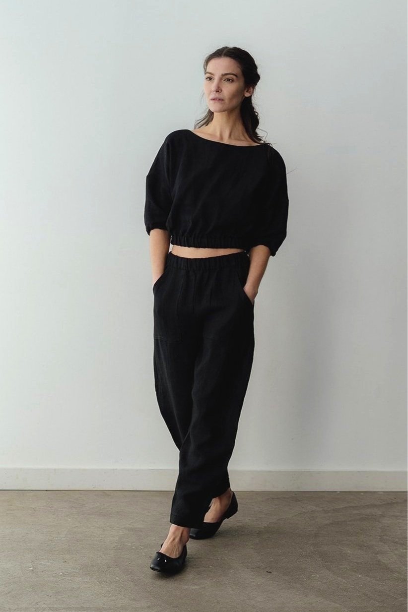 Front view of model wearing the Jordan linen pants in black with hands in pockets