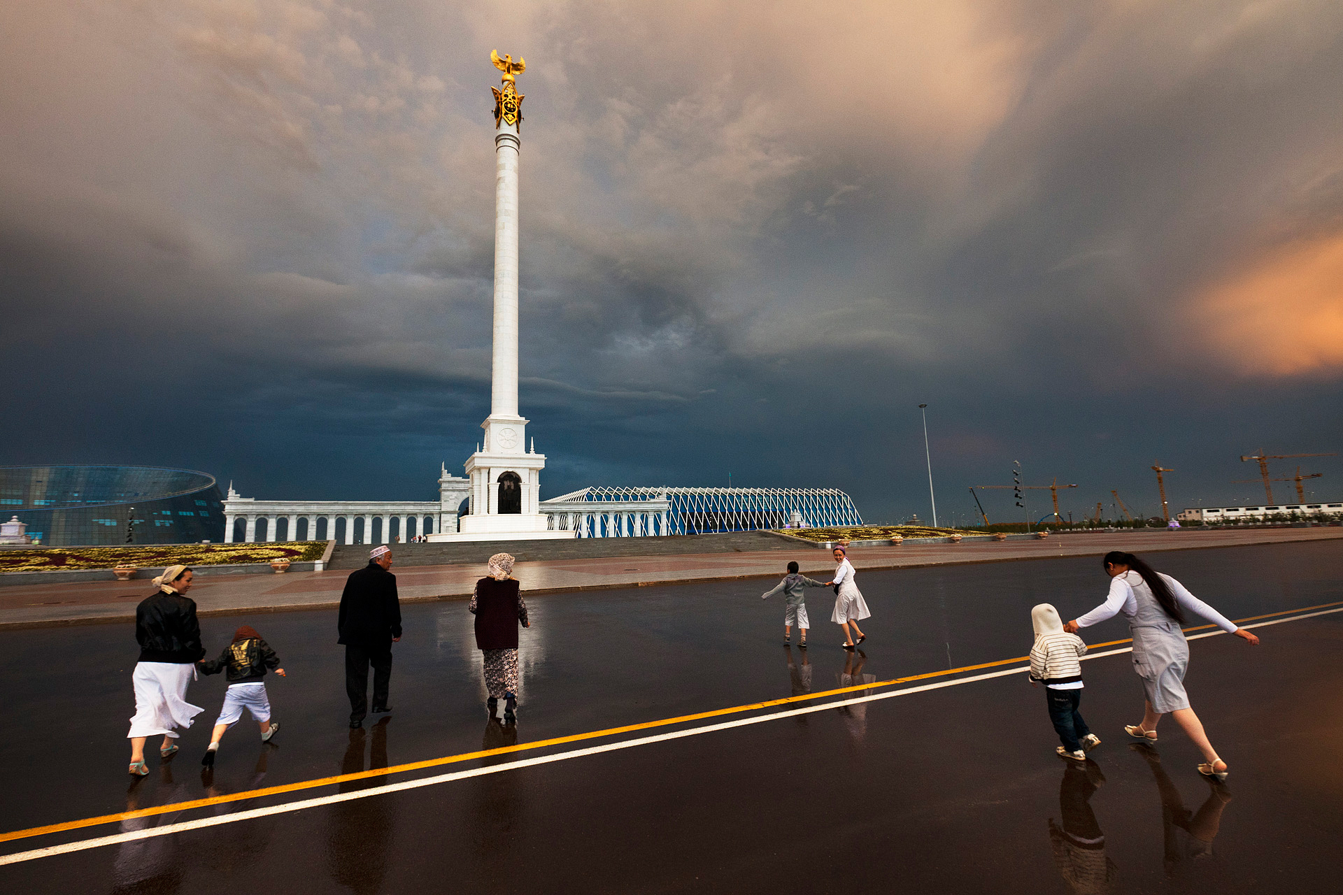  The alabaster-white pillar known as the Samruk monument is topped by a golden eagle, one of many nationalist symbols in Astana. The Samruk is a beacon for visitors like these ethnic Kazakhs from the southern city of Taraz.  Astana, Kazakhstan  
