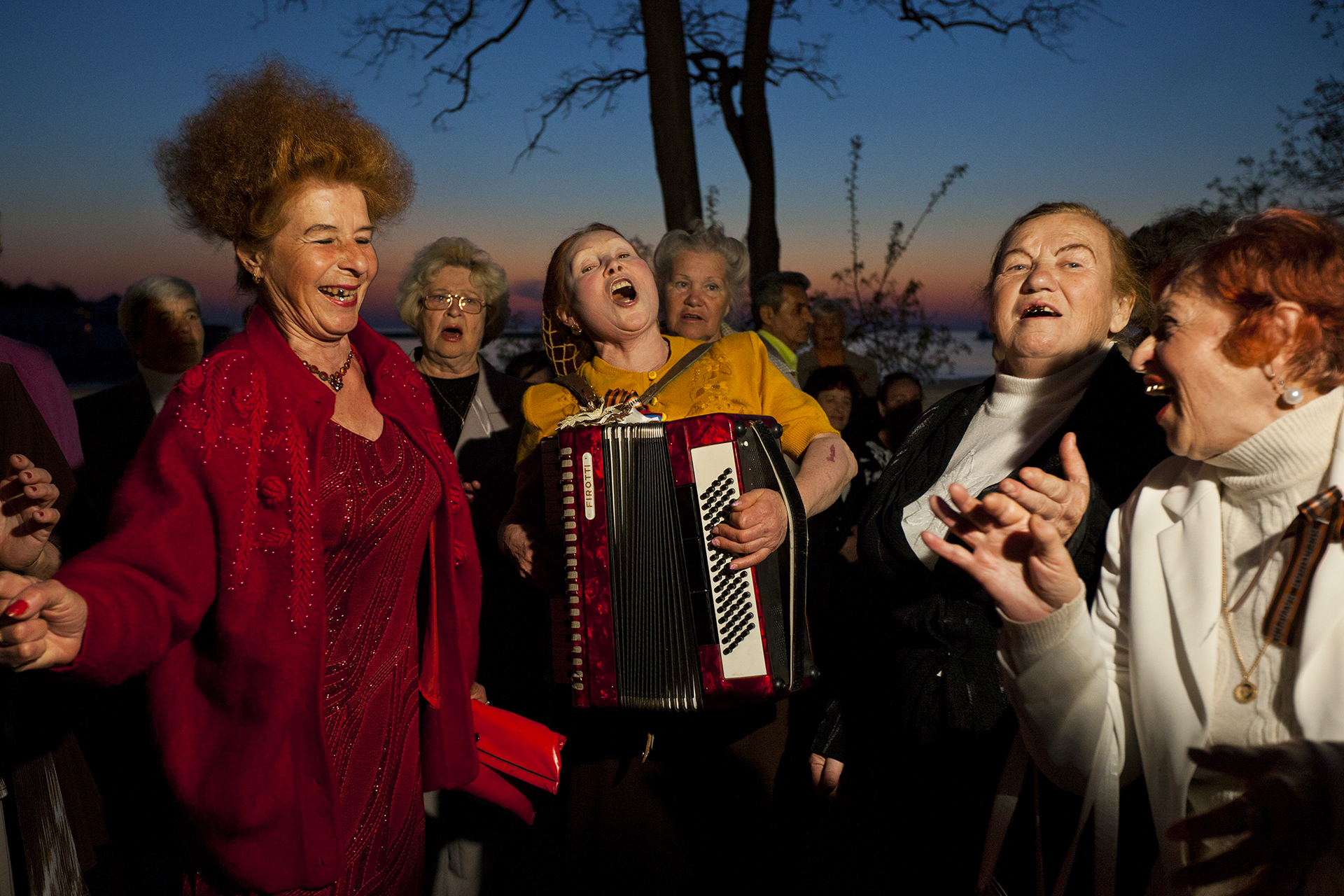  Chords of friendship bind accordionist Olesya Kamovich and comrades, who meet Sundays in Sevastopol on the promenade to sing and dance into the early night.  Sevastopol, Crimea  