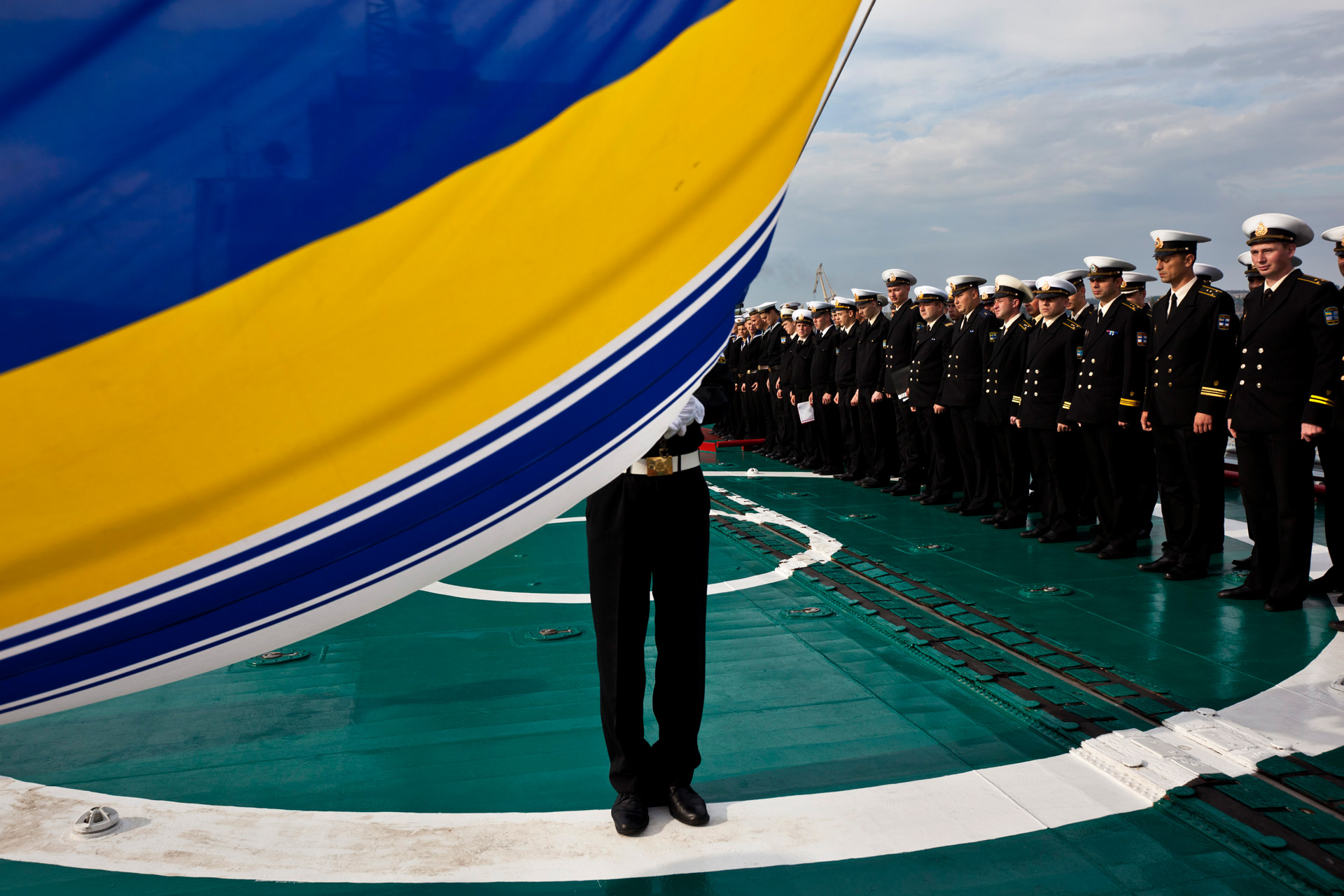  A Ukrainian Black Sea Fleet Navy soldier hoists his country’s flag during the routine morning salute.  Sevastopol, Crimea  