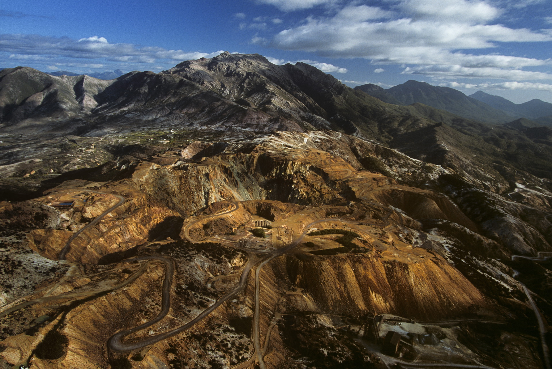  Aerial view of the Mount Lyell area near Queenstown, Tasmania, in Australia showing deep eroded gullies and bare multicolored hills due to open cut mining.  Queenstown, Tasmania  