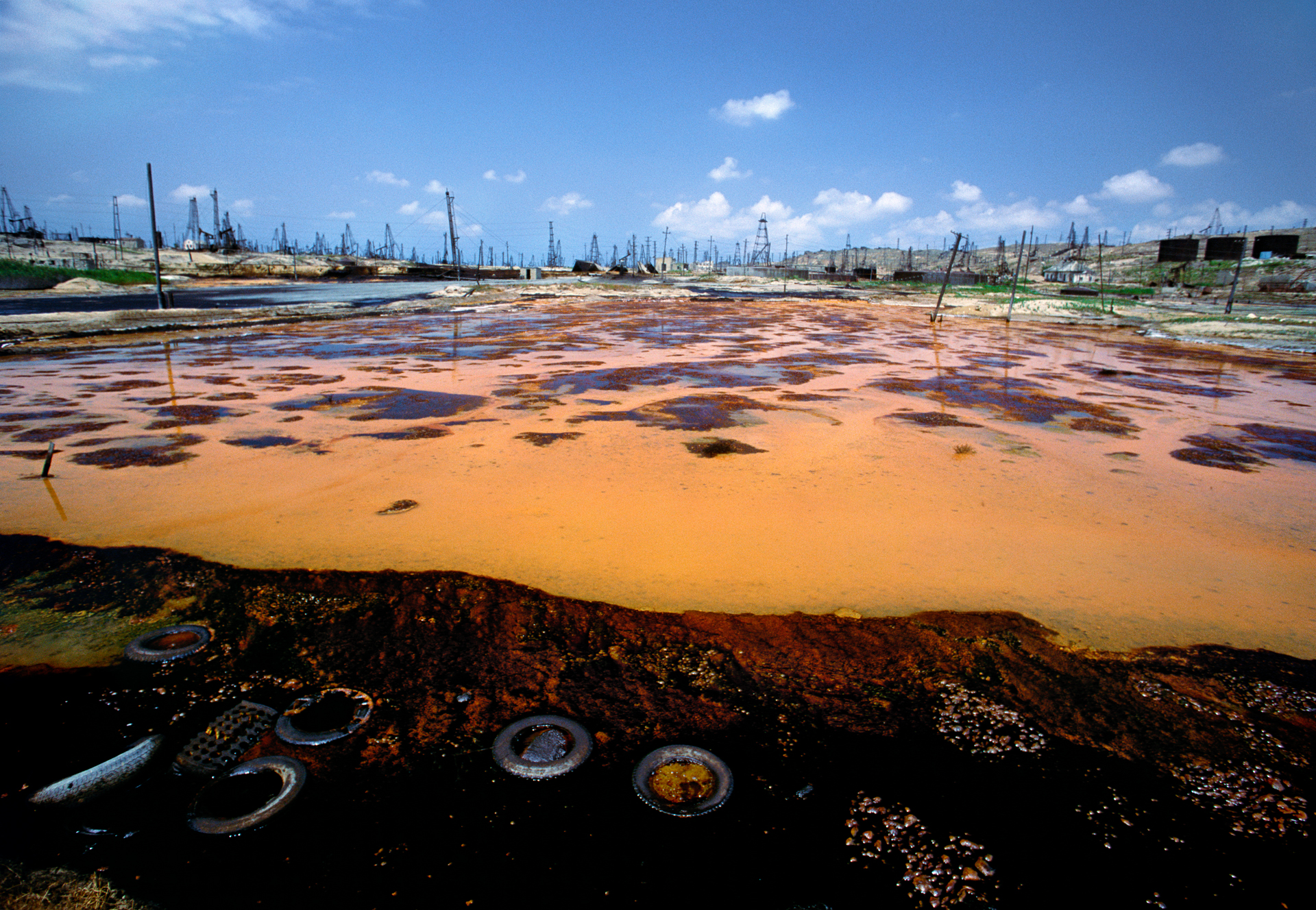  A gloss of oil and chemicals sheens standing water in an oil field near Baku. Runoff from the fields has rendered local streams, lakes and ponds biologically dead.  Baku, Azerbaijan  