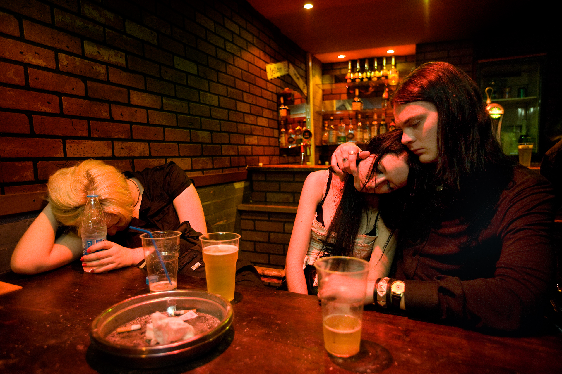  3:24AM - Drunk and tired from too much fun and booze, teens fall asleep at the table of a bar and club in the early morning hours. 