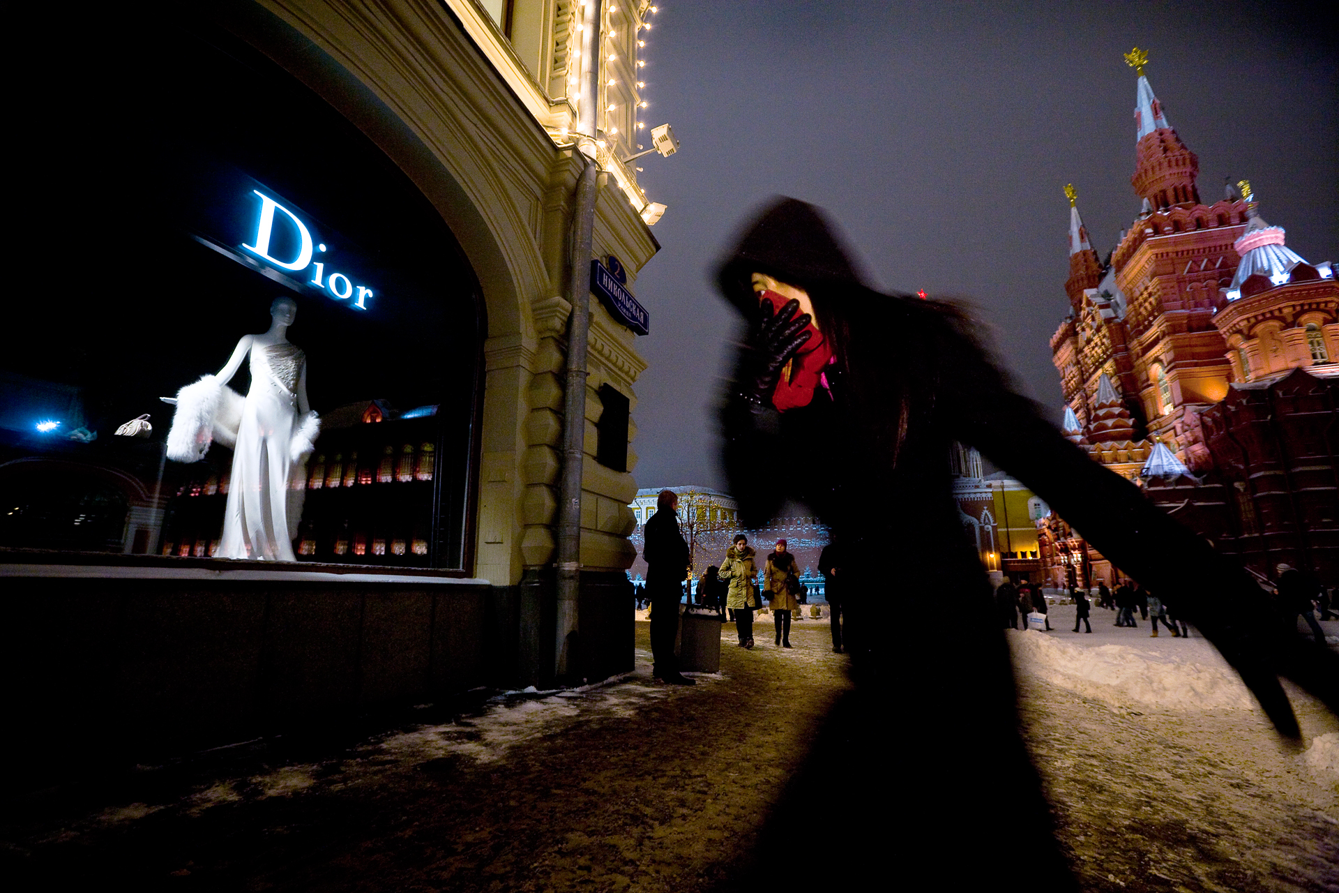  6:01PM - A shopper scythes through bitter cold to reach a boutique on Red Square. These materialistic days, Marx and Lenin can't compete with Dior and Armani for the hearts of the consuming class. 