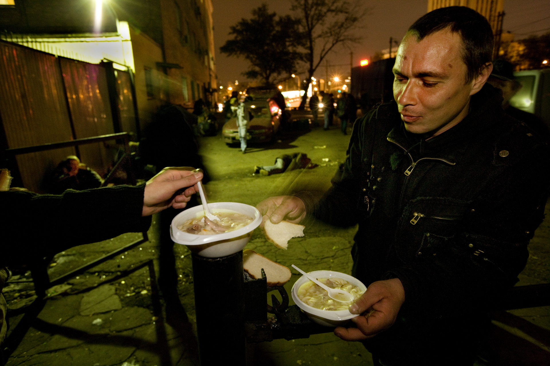  9:19 PM - A mobile food kitchen stops outside a train station to deliver warm soup and bread to the homeless. 