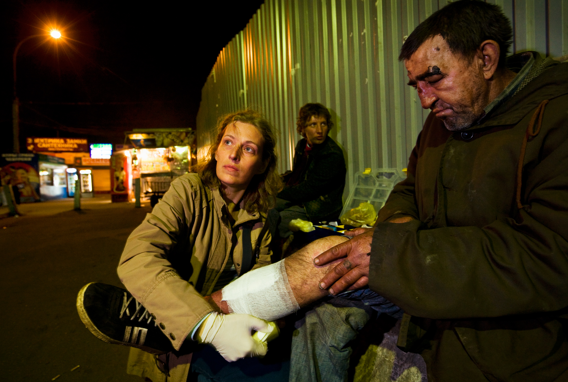  10:45PM - Angel of the night, volunteer Tatyana Sveshnikova, attends to a battered homeless man near Kursk Station with aid collected from personal friends and family. 