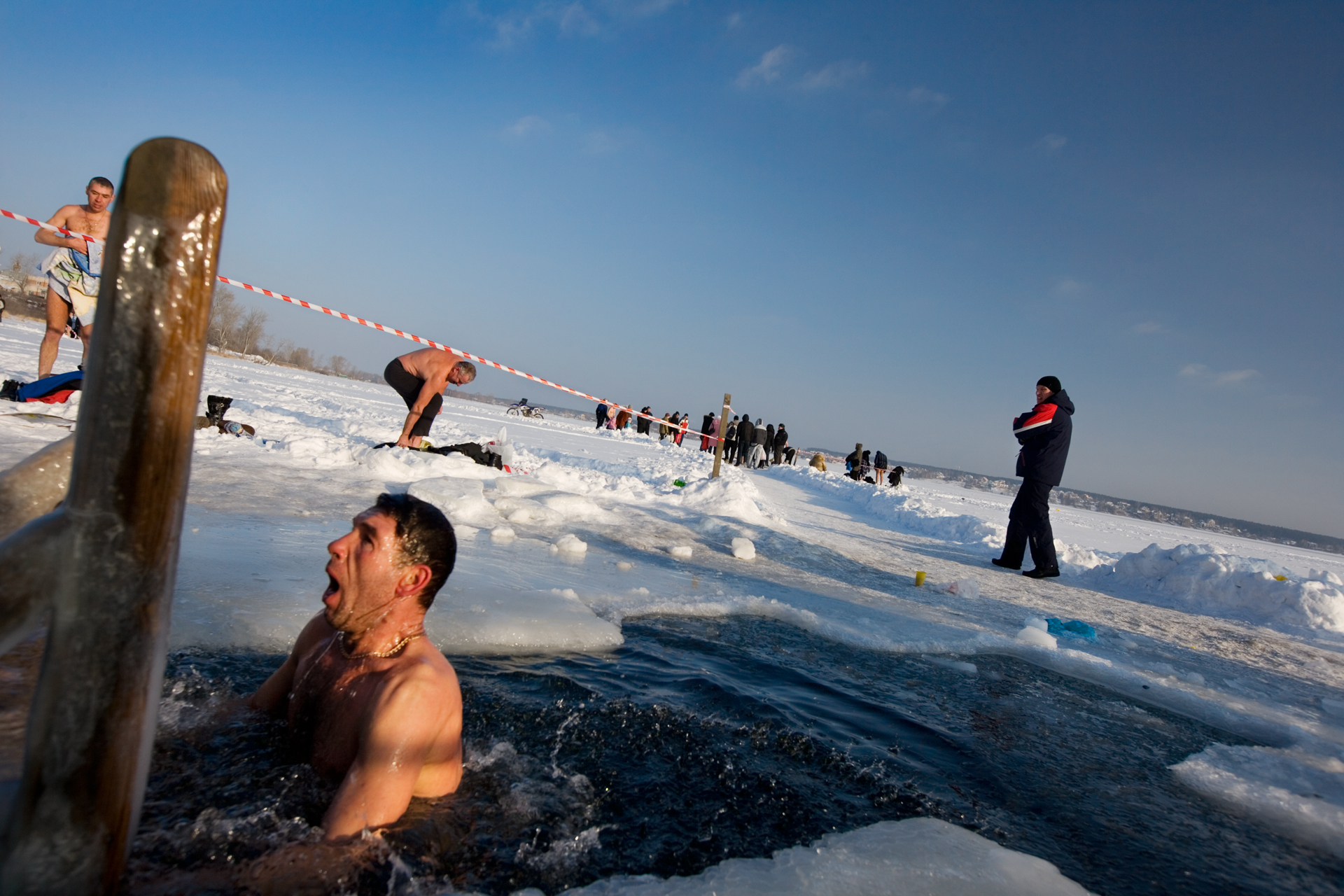  Pious in the extreme, a parishioner gasps after plunging into a cross-shaped hole cut into Lake Shartash at Epiphany.  Yekaterinburg, Russia  